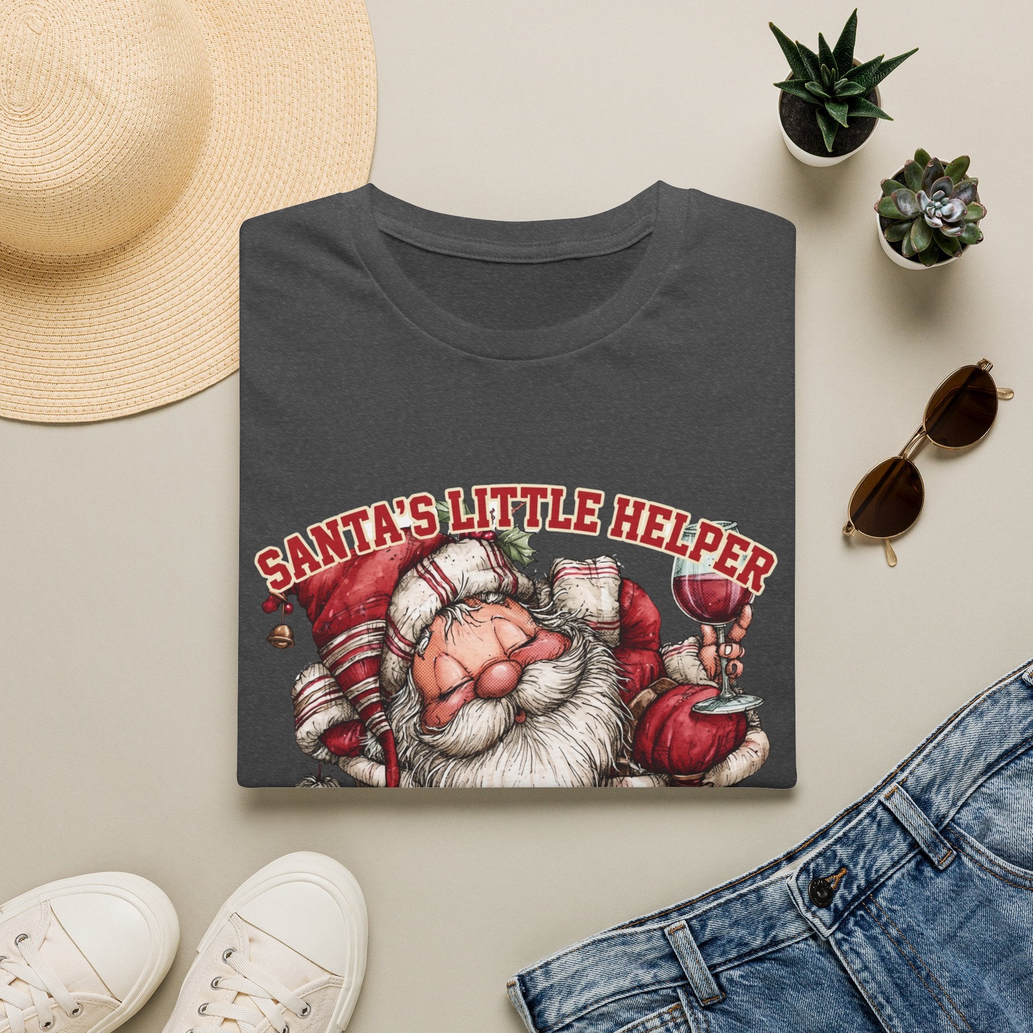 Santa's Little Helper Is Lit Christmas Wine print on a Dark Heather t-shirt, folded beside a straw hat and jeans