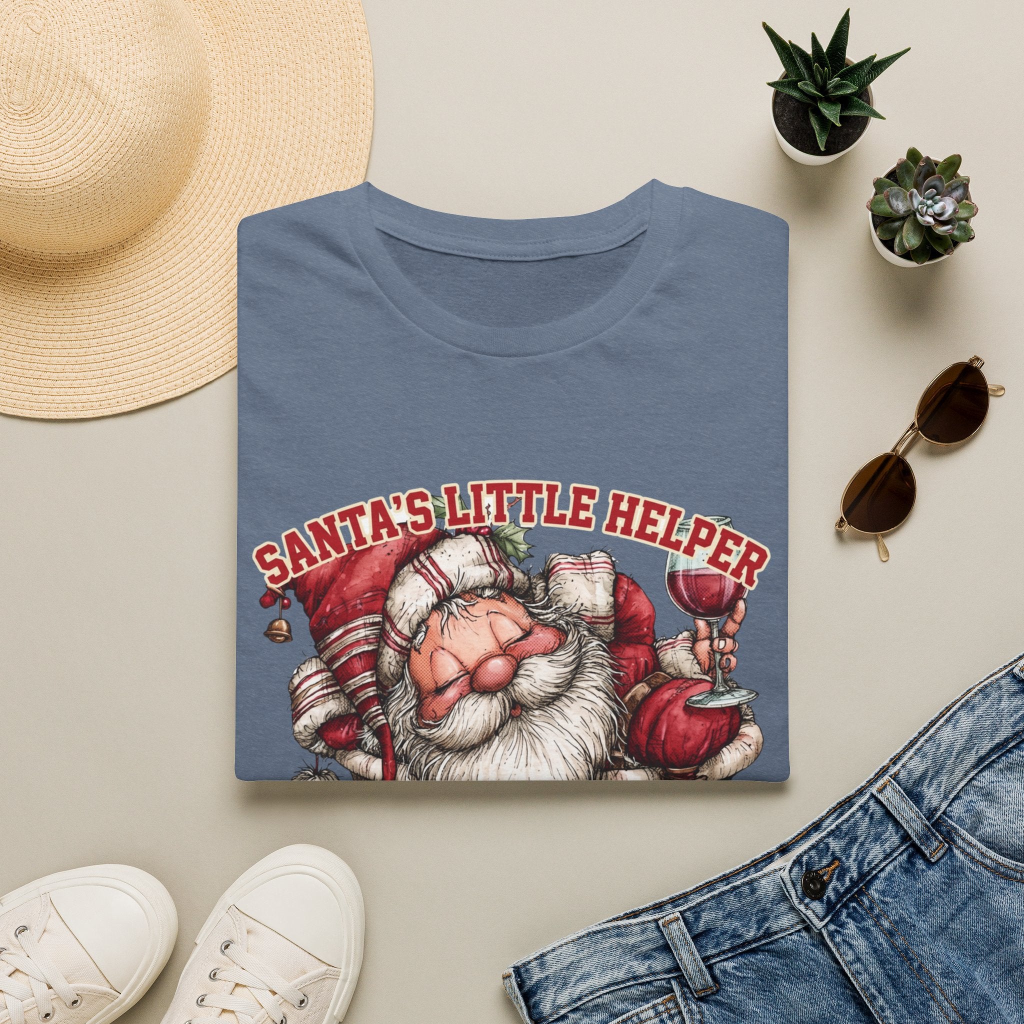 Santa's Little Helper Is Lit Christmas Wine print on a Heather Indigo t-shirt, folded beside a straw hat and jeans