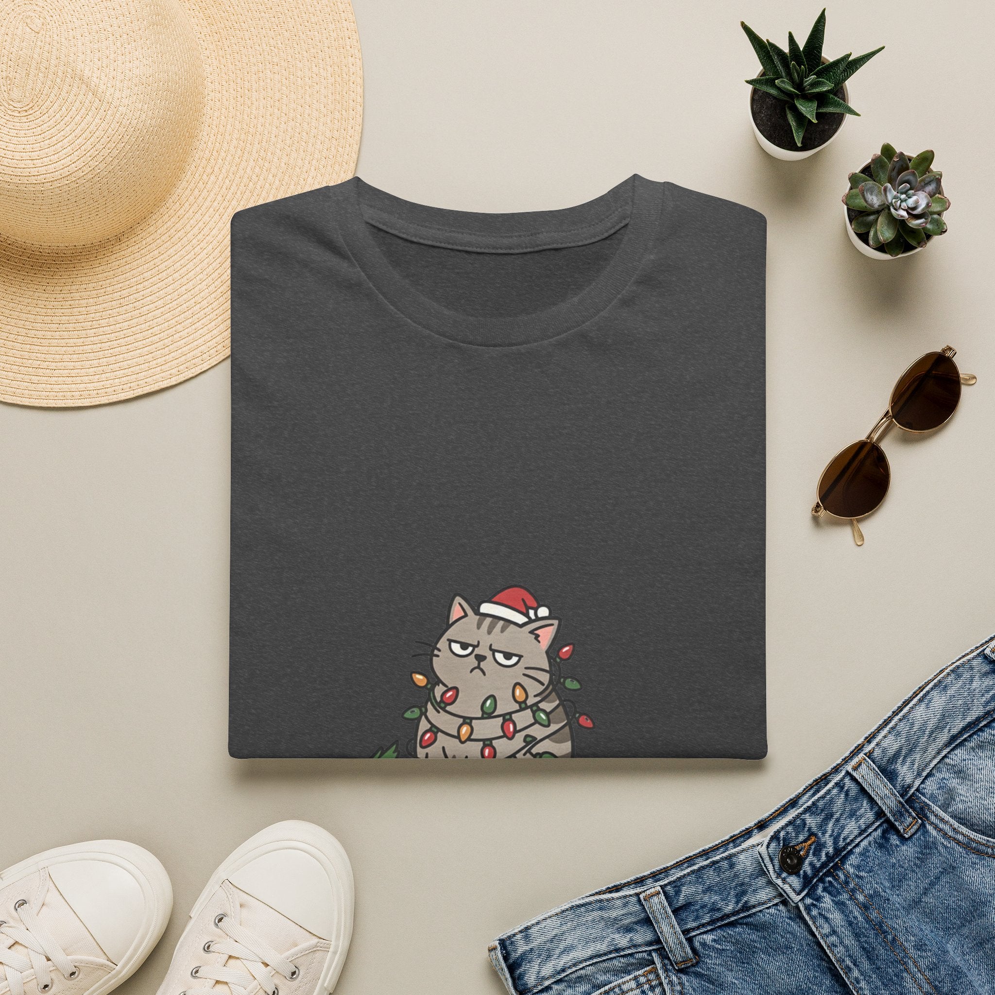 Funny Cat I'm Only Here for the Presents print on a Dark Heather t-shirt, folded beside a straw hat and jeans