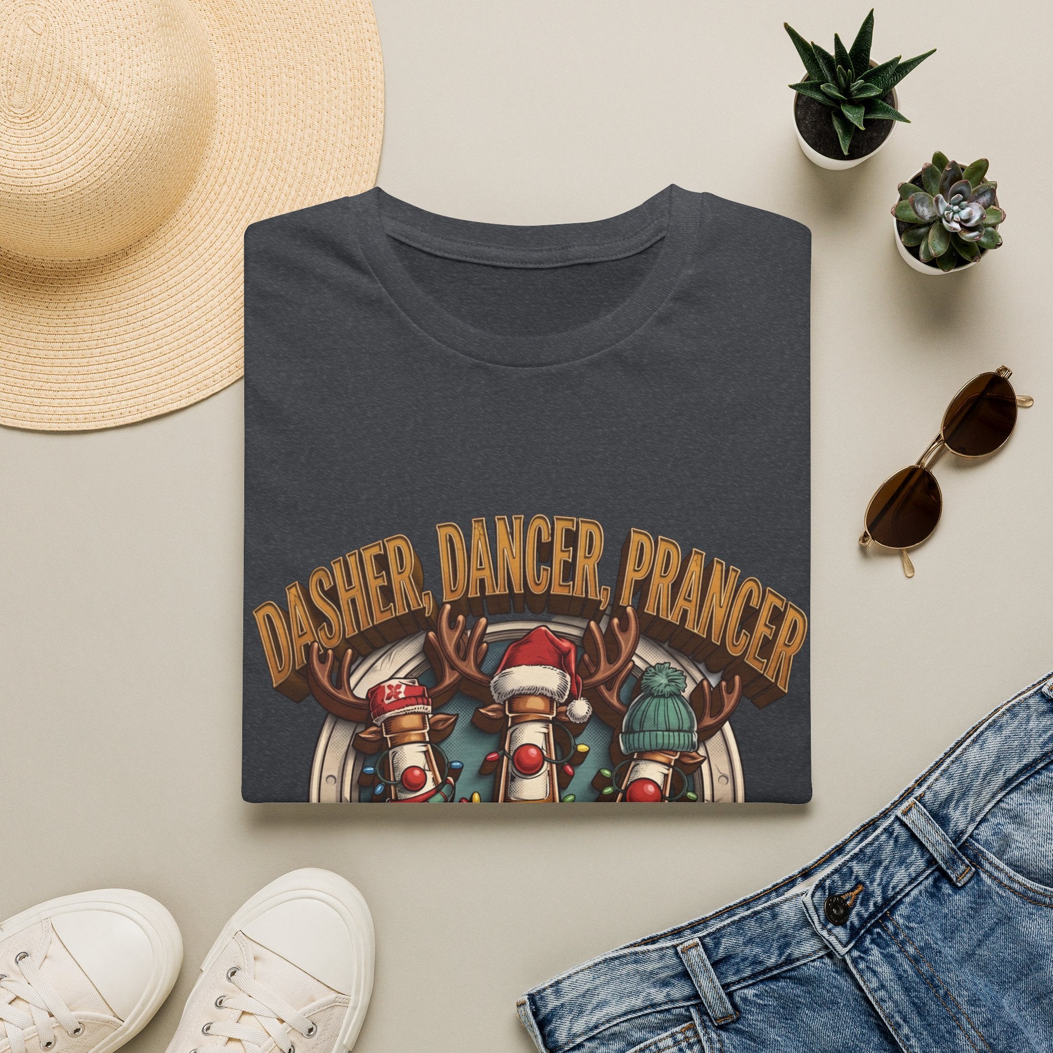 Dasher Dancer Prancer Reinbeer Christmas Beer print on a Dark Heather Grey t-shirt, folded beside a straw hat and jeans