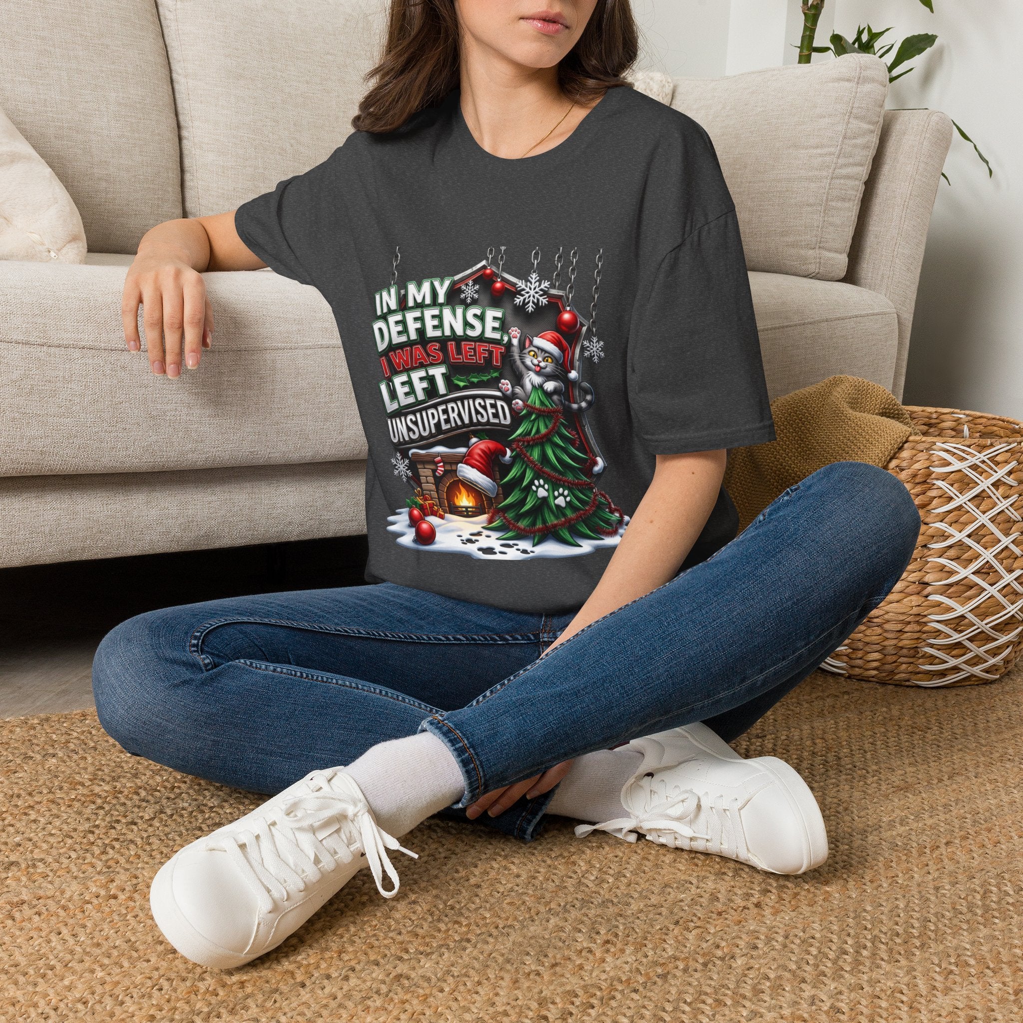Cat In My Defense Left Unsupervised t-shirt in Dark Heather, worn by a woman seated on a rug