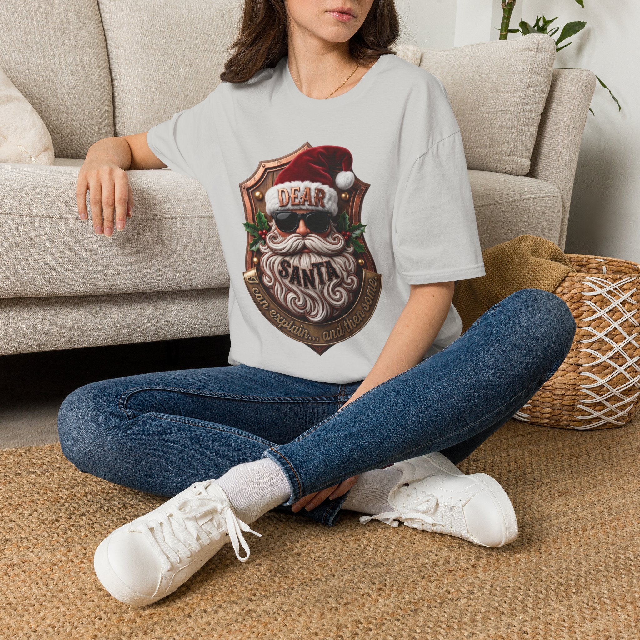 Dear Santa I Can Explain Sunglasses Crest t-shirt in Ice Grey, worn by a woman seated on a rug