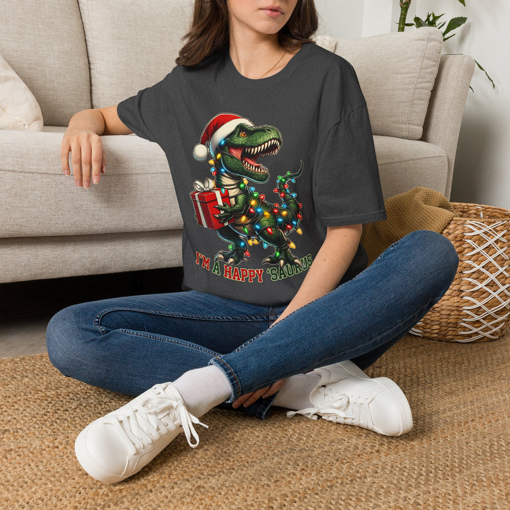Happy Saurus T-Rex Santa Hat Christmas Lights t-shirt in Dark Heather, worn by a woman seated on a rug