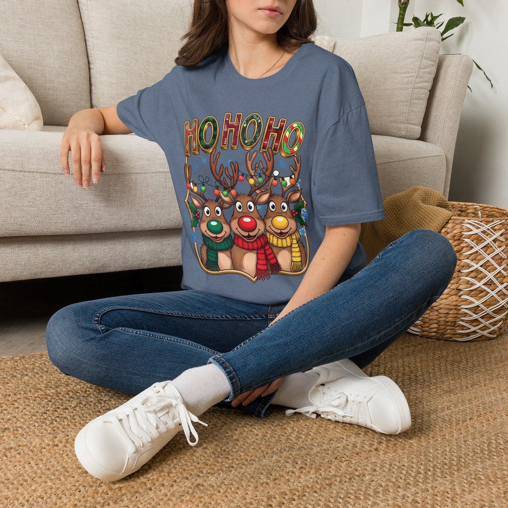Reindeer Trio Ho Ho Ho Christmas Lights t-shirt in Heather Indigo, worn by a woman seated on a rug