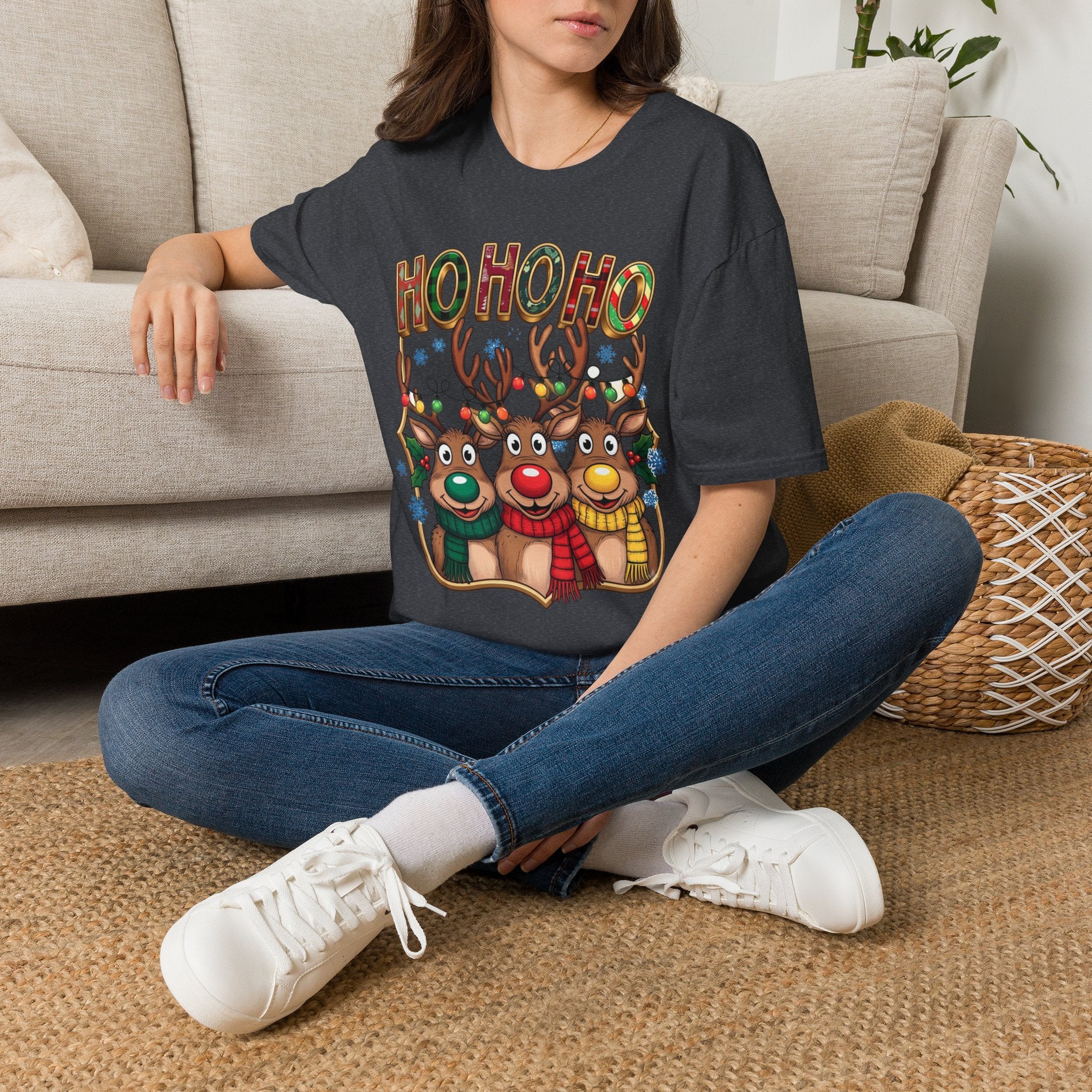 Reindeer Trio Ho Ho Ho Christmas Lights t-shirt in Dark Heather Grey, worn by a woman seated on a rug