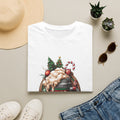 XMAS Beer Pour Me a Very Merry Christmas print on a White t-shirt, folded beside a straw hat and jeans