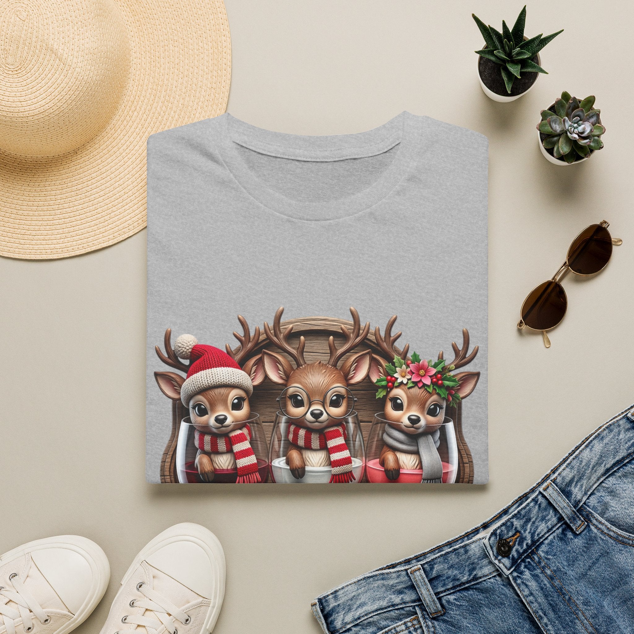 Drink Drank Drunk Reindeer Wine Trio print on a Sport Grey t-shirt, folded beside a straw hat and jeans