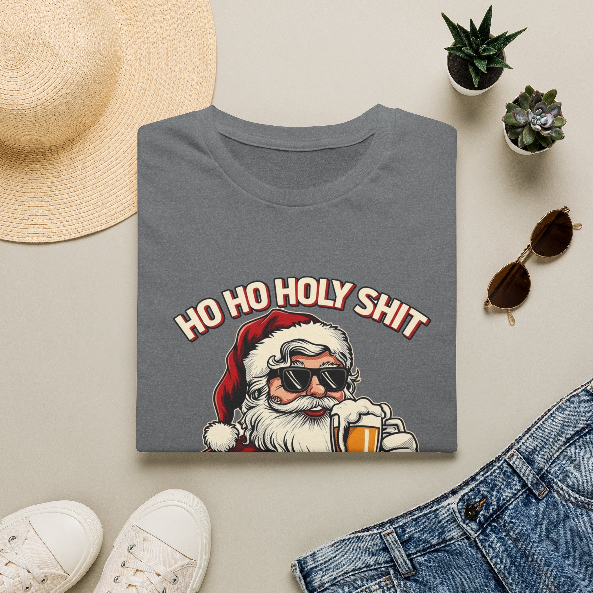 Ho Ho Holy Sh*t I Need a Beer print on a Graphite Heather t-shirt, folded beside a straw hat and jeans