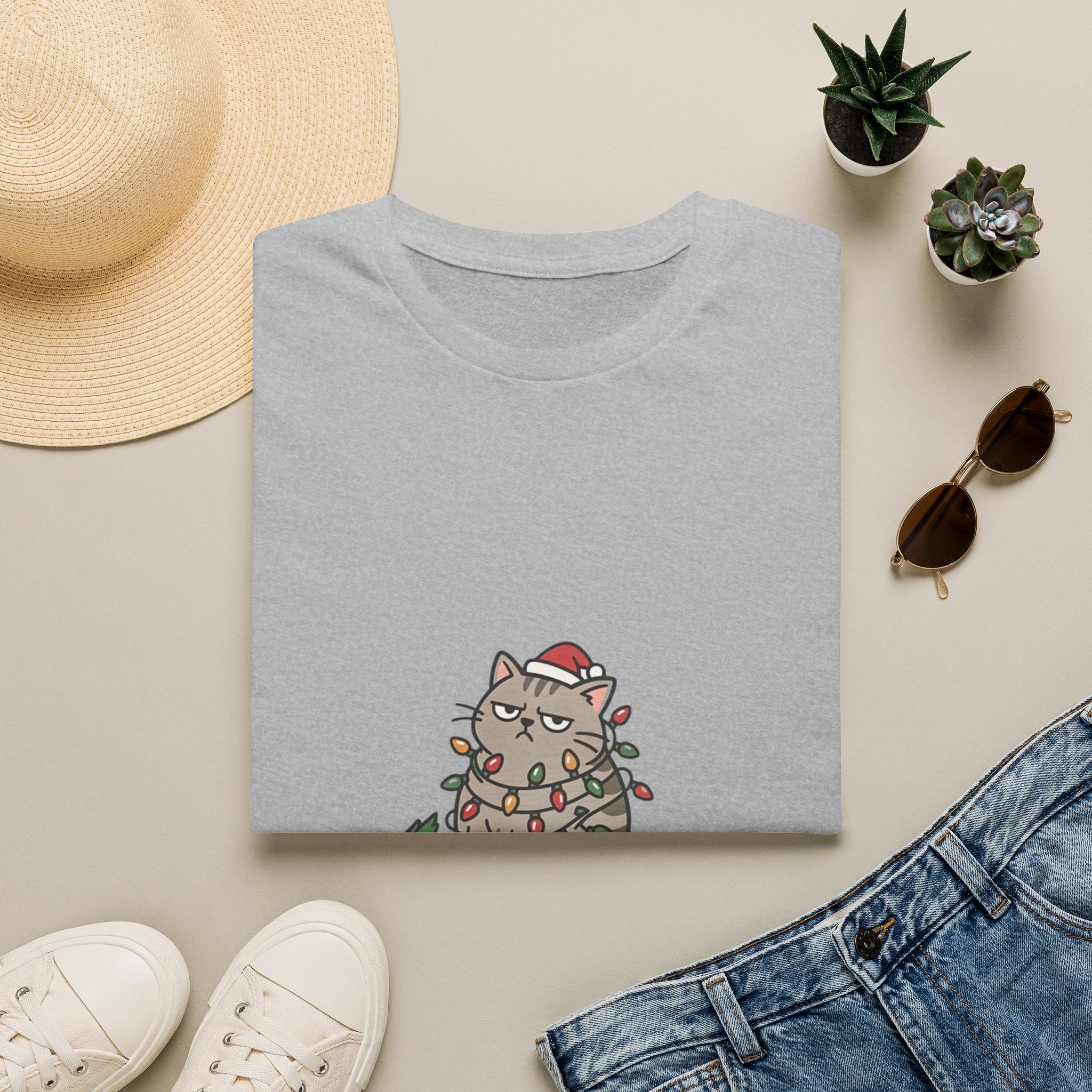 Funny Cat I'm Only Here for the Presents print on a Sport Grey t-shirt, folded beside a straw hat and jeans