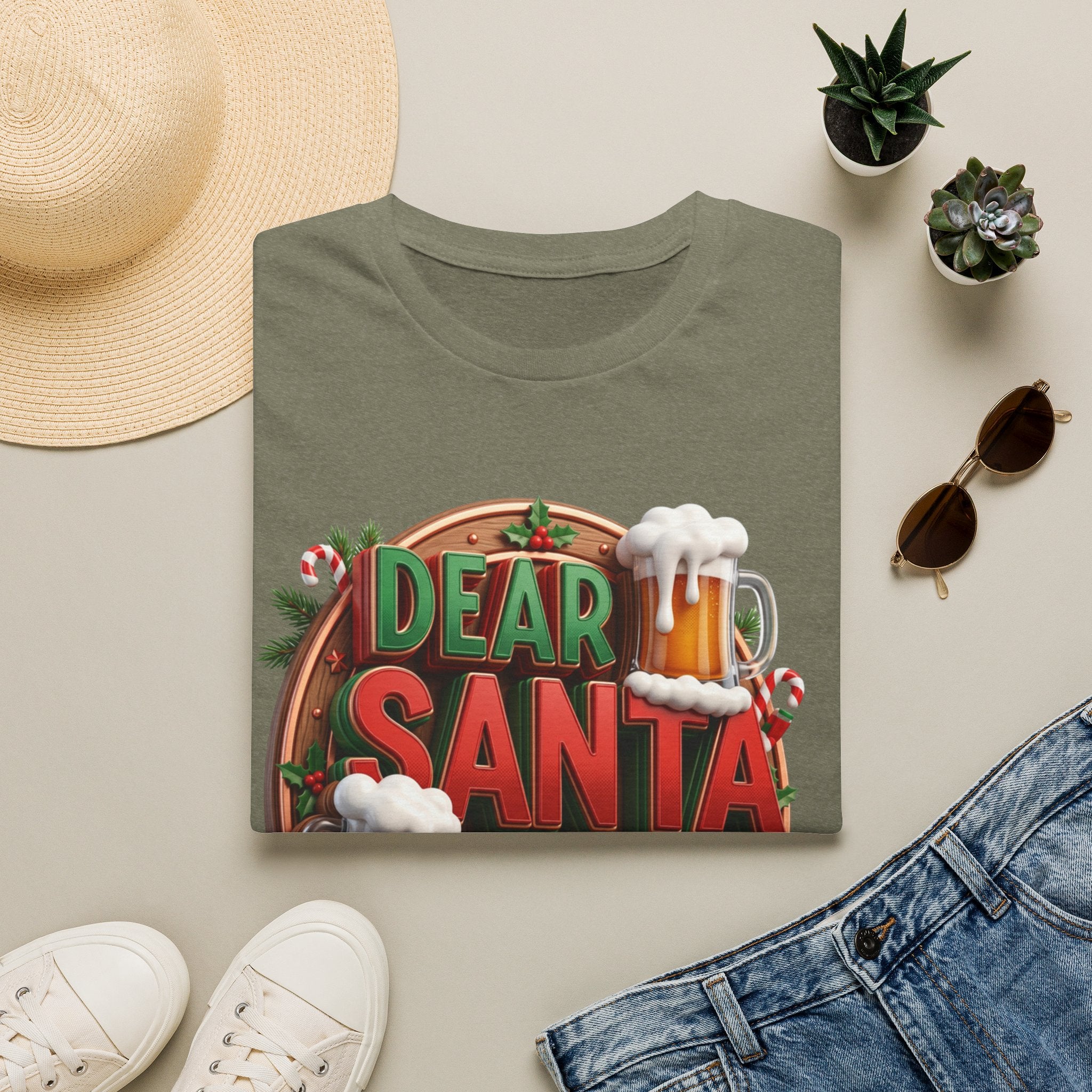 Dear Santa Just Bring Beer Funny print on a Heather Military Green t-shirt, folded beside a straw hat and jeans
