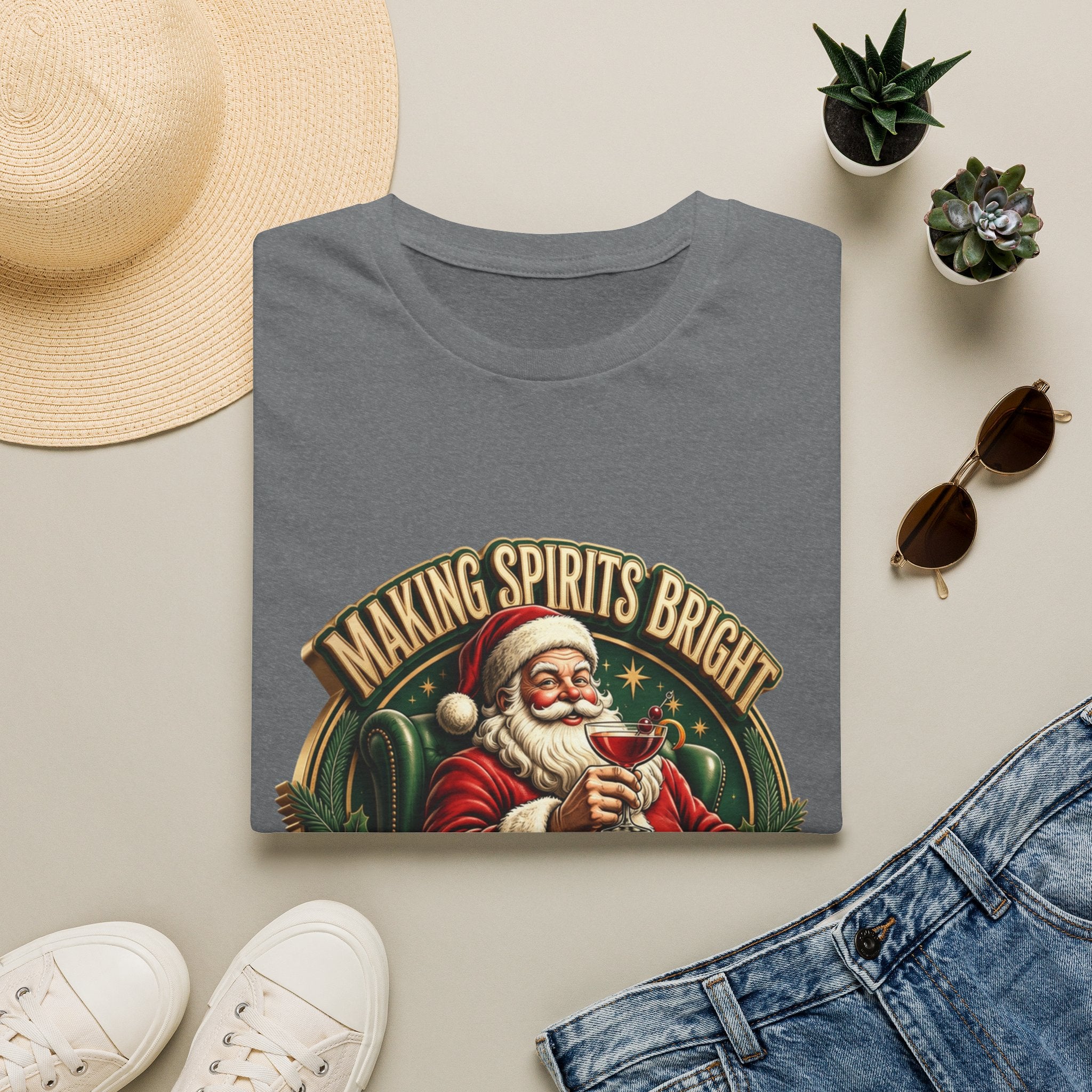 Making Spirits Bright and Stronger Santa print on a Graphite Heather t-shirt, folded beside a straw hat and jeans