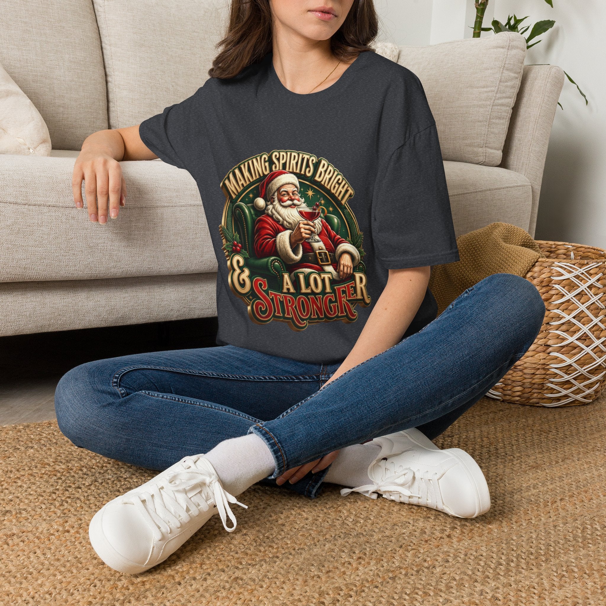 Making Spirits Bright and Stronger Santa t-shirt in Dark Heather Grey, worn by a woman seated on a rug