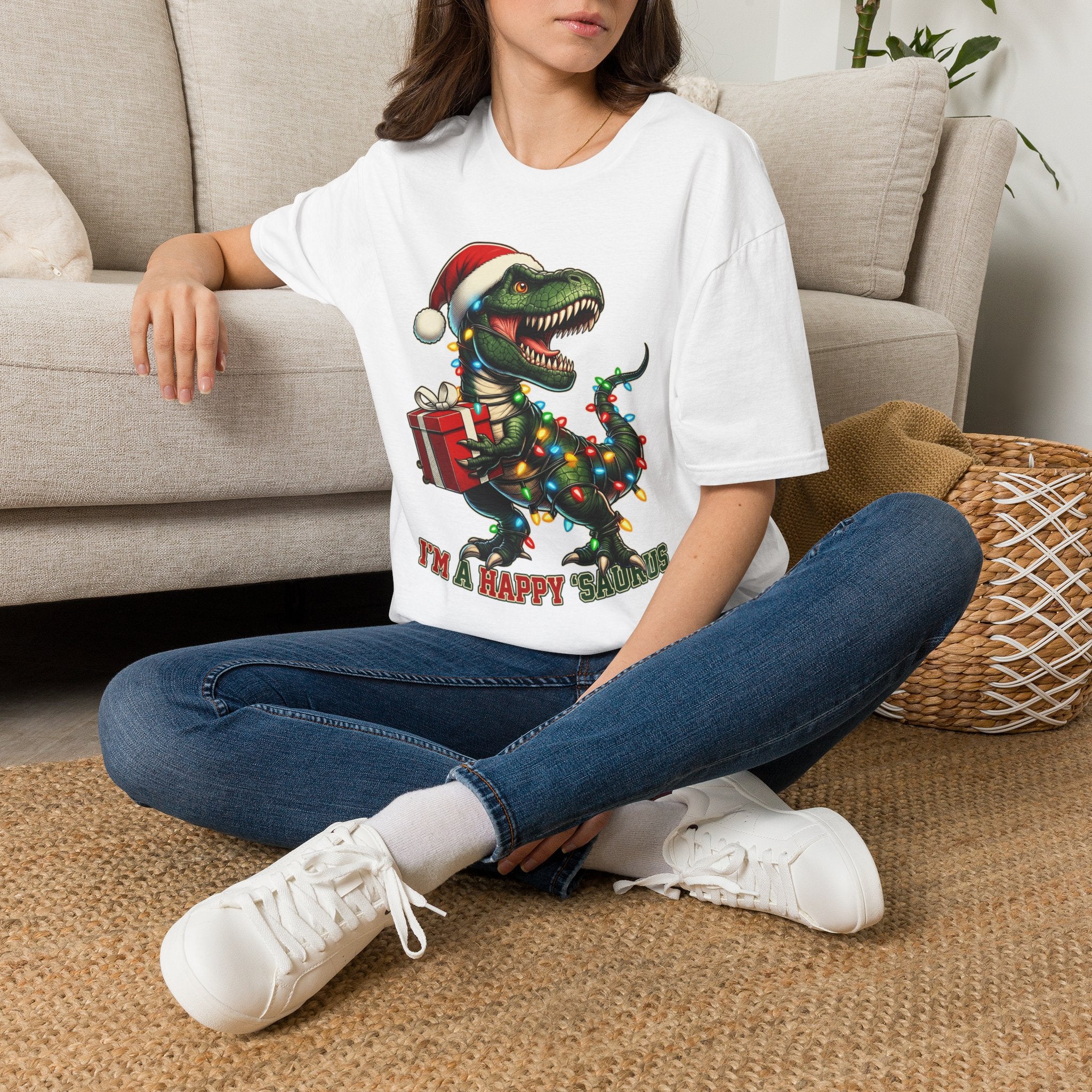 Happy Saurus T-Rex Santa Hat Christmas Lights t-shirt in White, worn by a woman seated on a rug