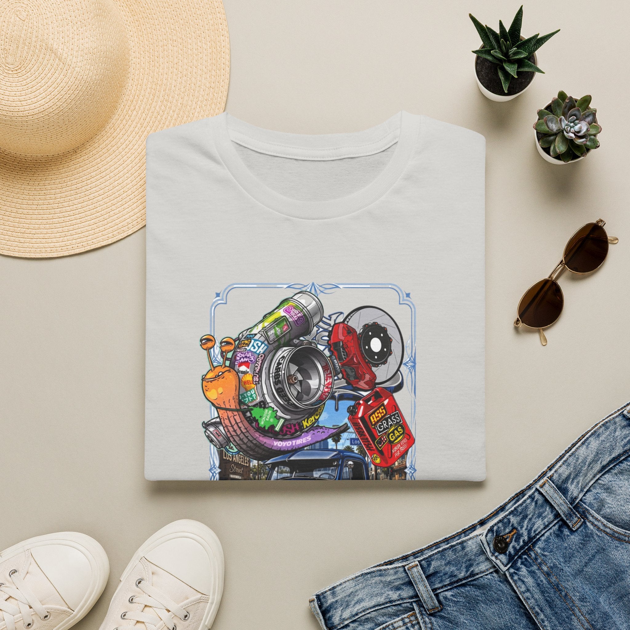 Turbocharged Snail Gearhead Car Parts print on an Ice Grey t-shirt, folded beside a straw hat and jeans