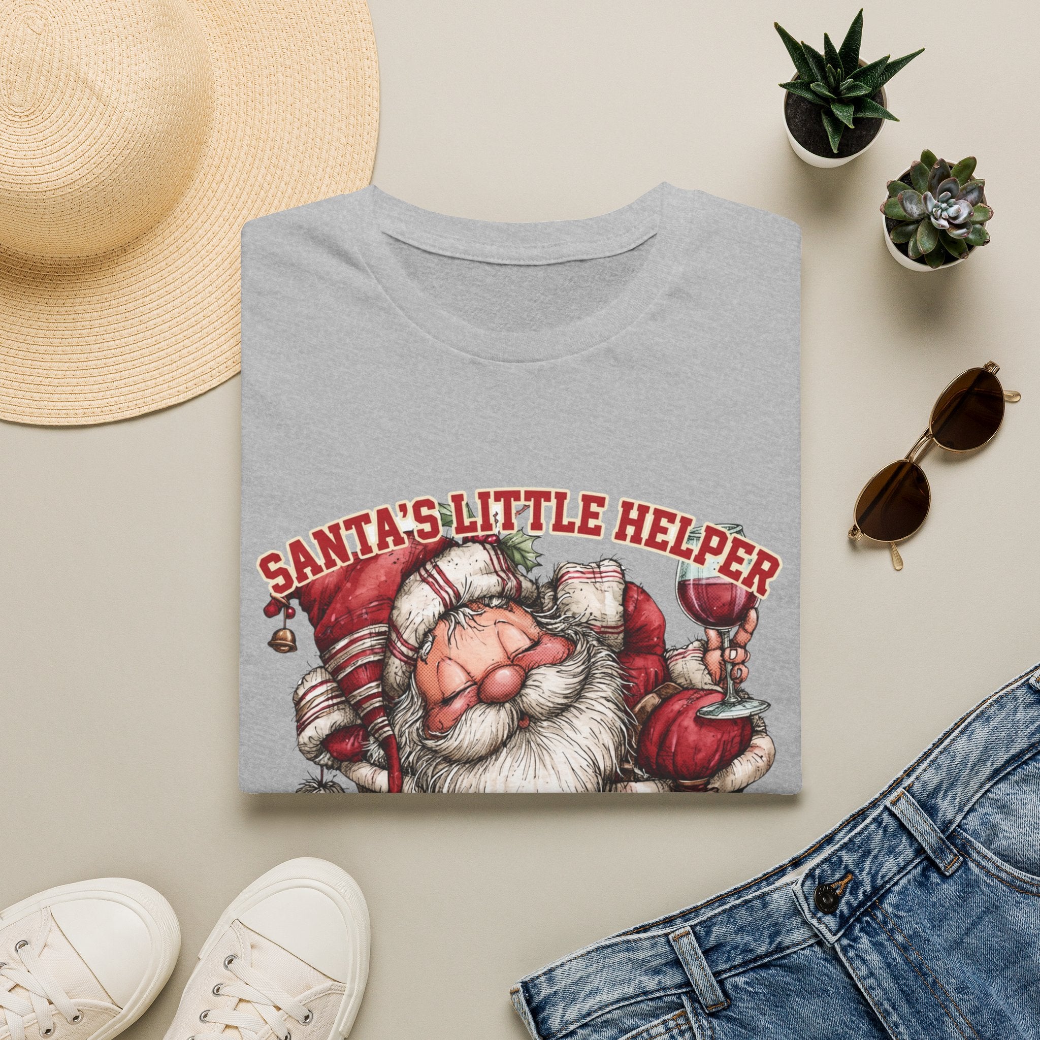 Santa's Little Helper Is Lit Christmas Wine print on a Sport Grey t-shirt, folded beside a straw hat and jeans
