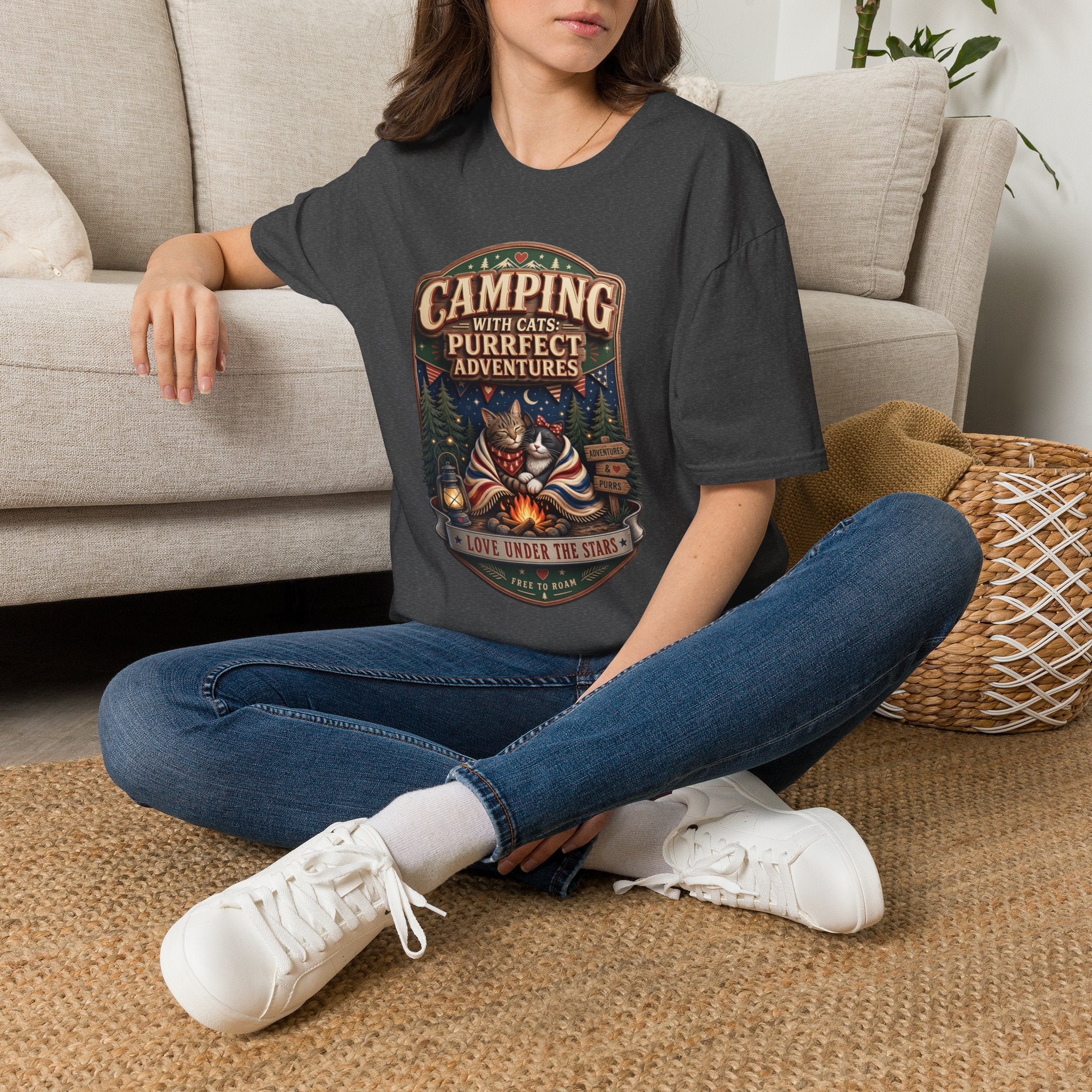 Camping With Cats Purrfect Adventures t-shirt in Dark Heather, worn by a woman seated on a rug