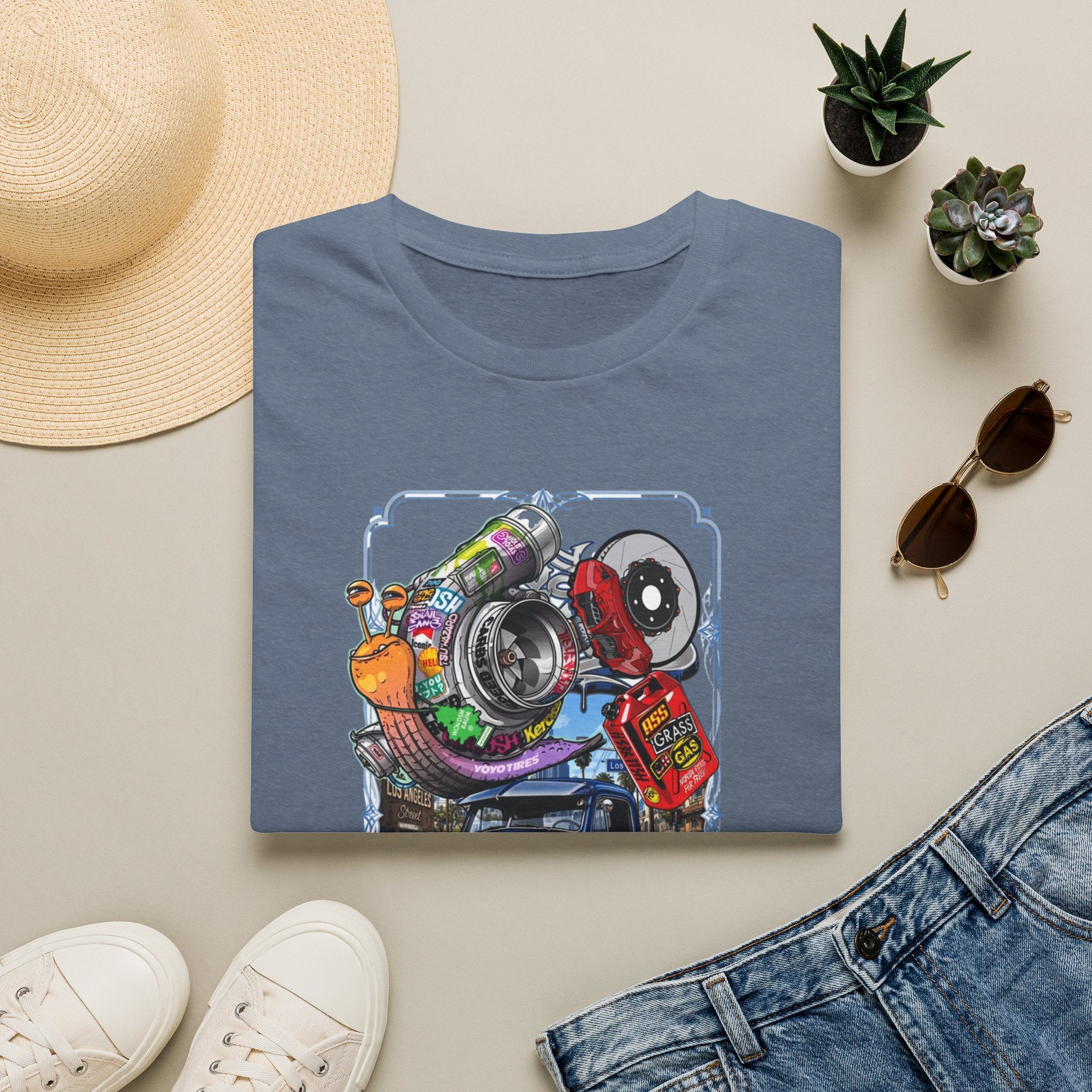 Turbocharged Snail Gearhead Car Parts print on a Heather Indigo t-shirt, folded beside a straw hat and jeans