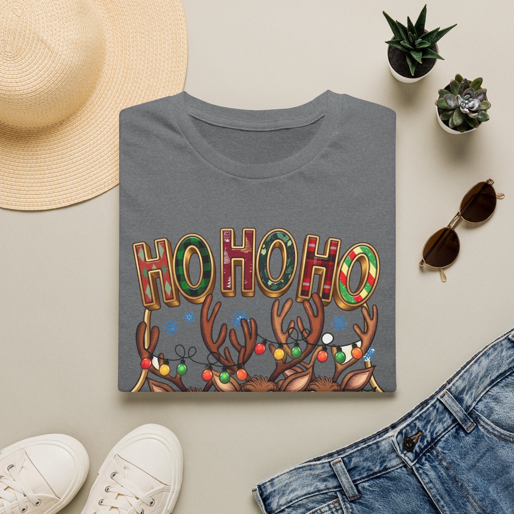 Reindeer Trio Ho Ho Ho Christmas Lights print on a Graphite Heather t-shirt, folded beside a straw hat and jeans