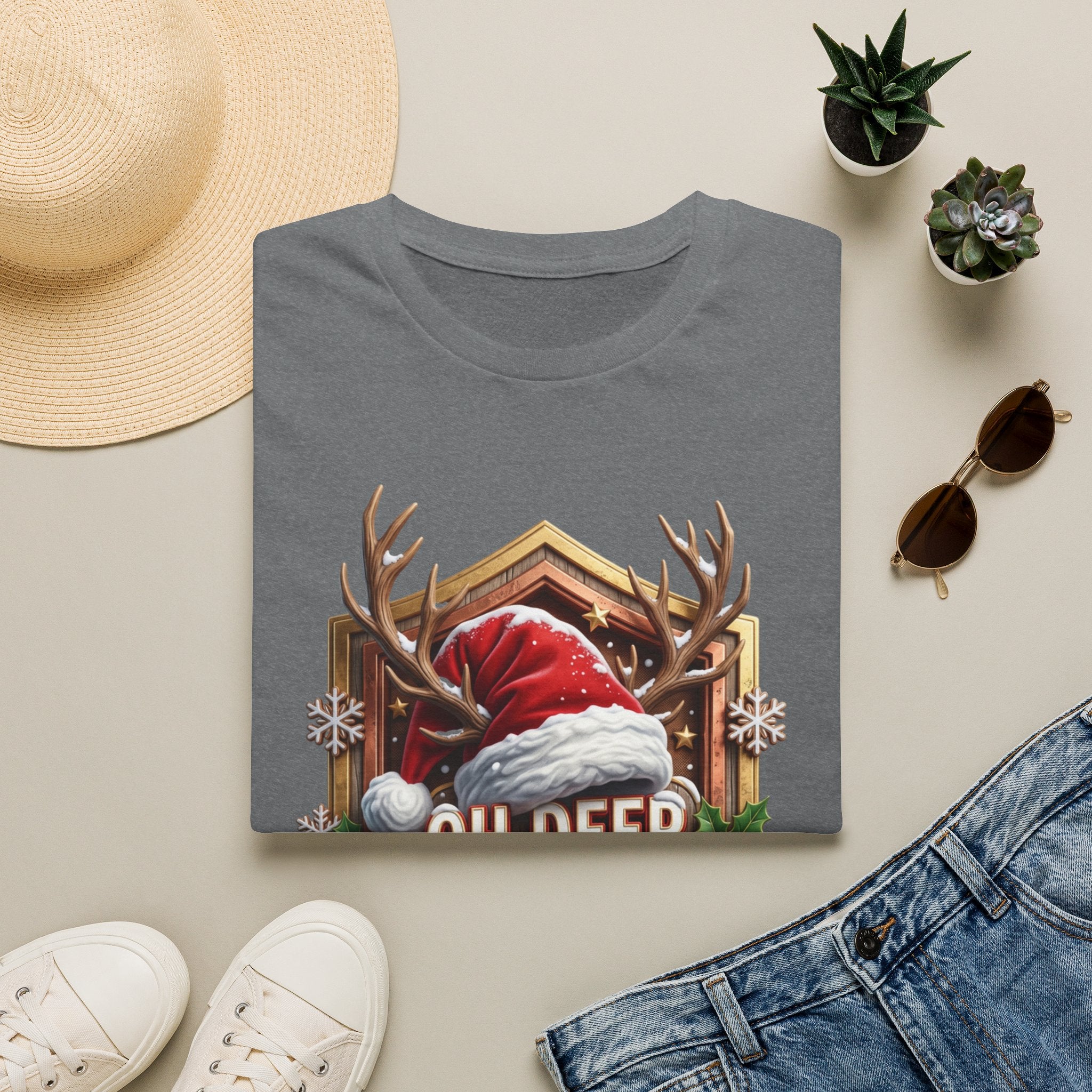 Oh Deer It's Christmas Looks a Lot Like Cocktails print on a Graphite Heather t-shirt, folded beside a straw hat and jeans