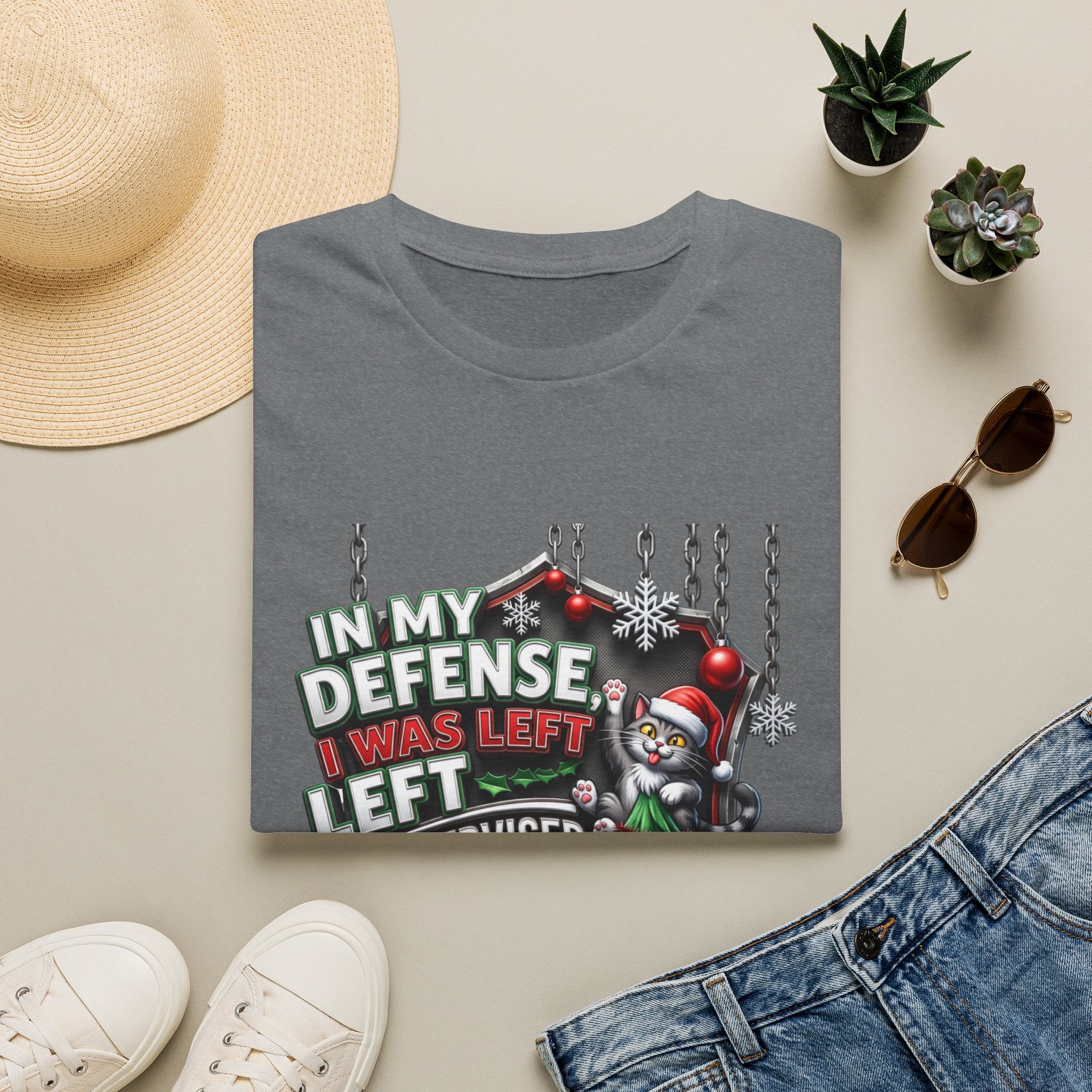 Cat In My Defense Left Unsupervised print on a Graphite Heather t-shirt, folded beside a straw hat and jeans