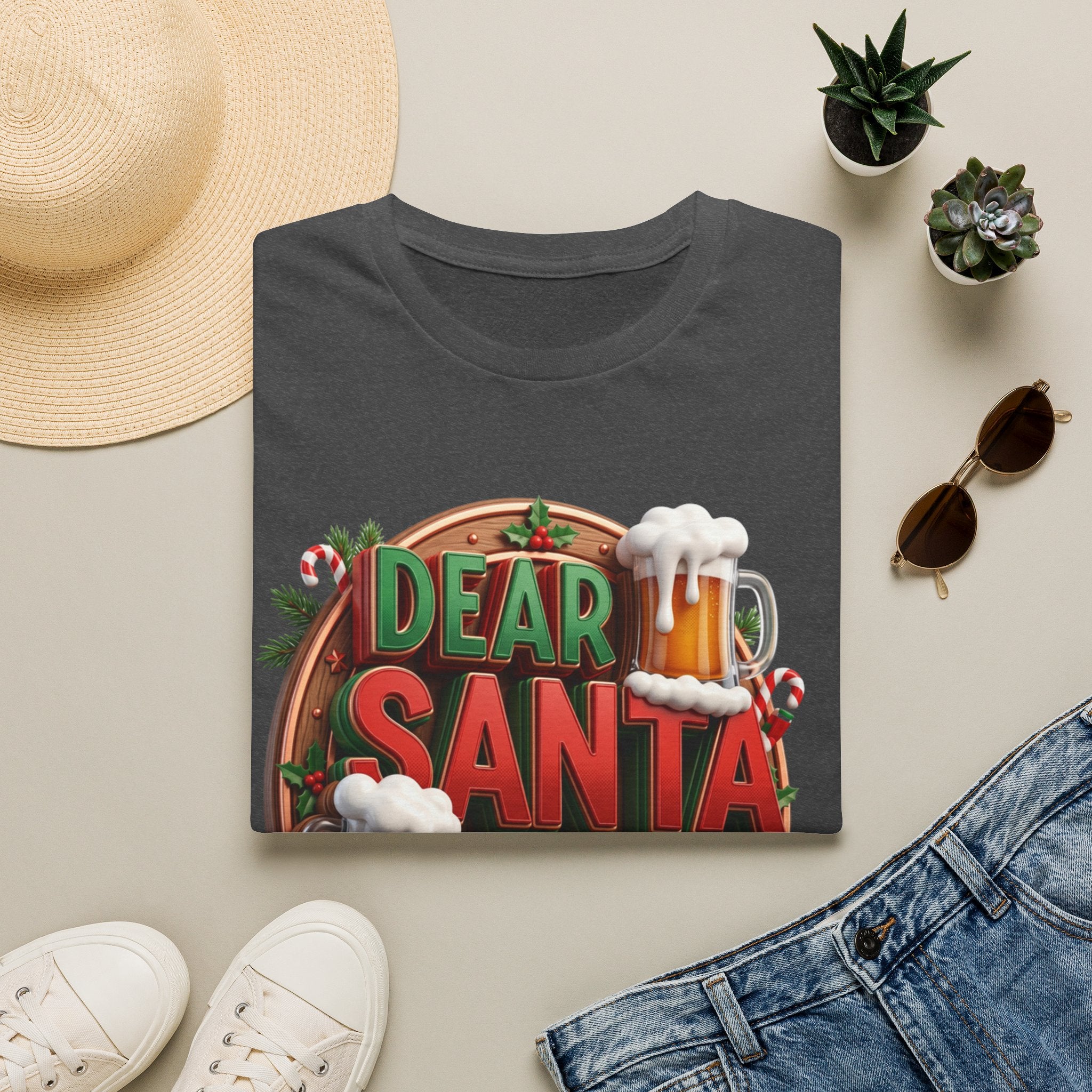 Dear Santa Just Bring Beer Funny print on a Dark Heather t-shirt, folded beside a straw hat and jeans