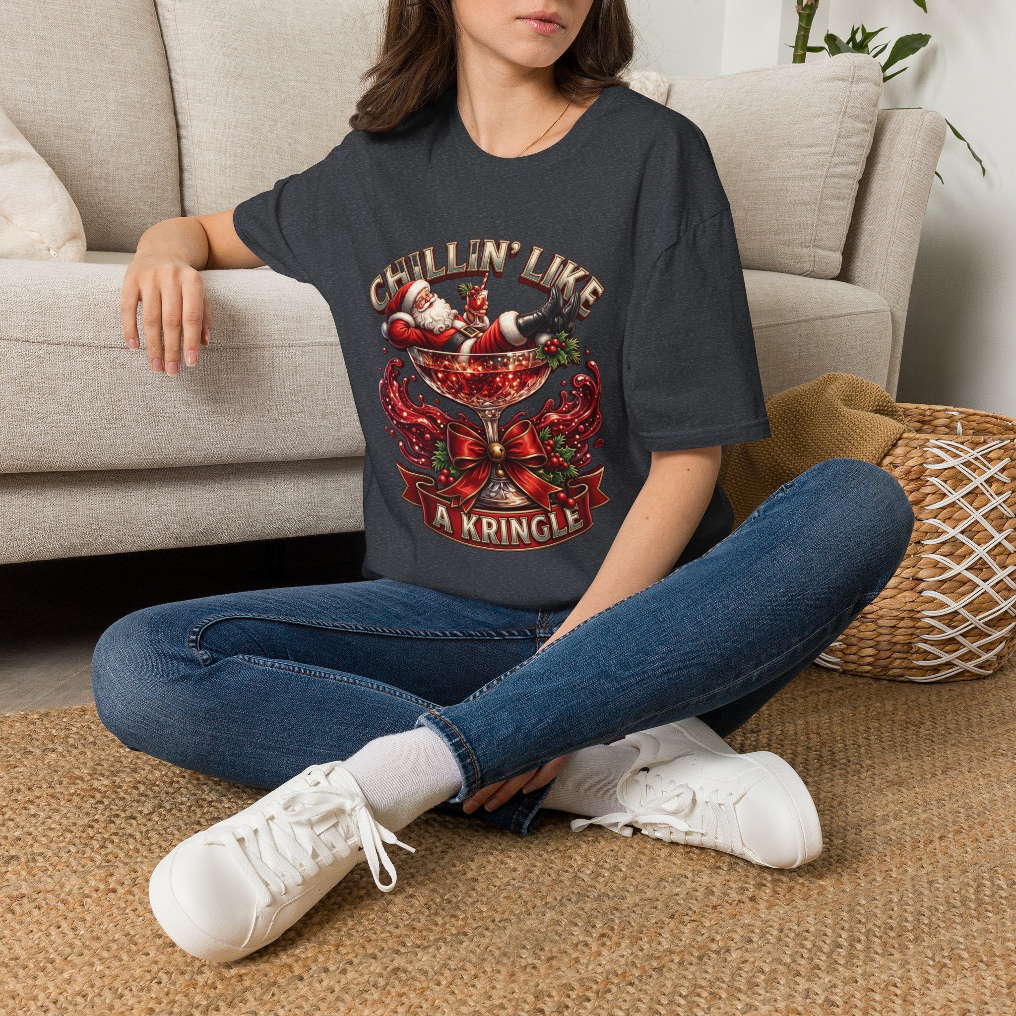 Chillin' Like a Kringle Santa t-shirt in Dark Heather Grey, worn by a woman seated on a rug