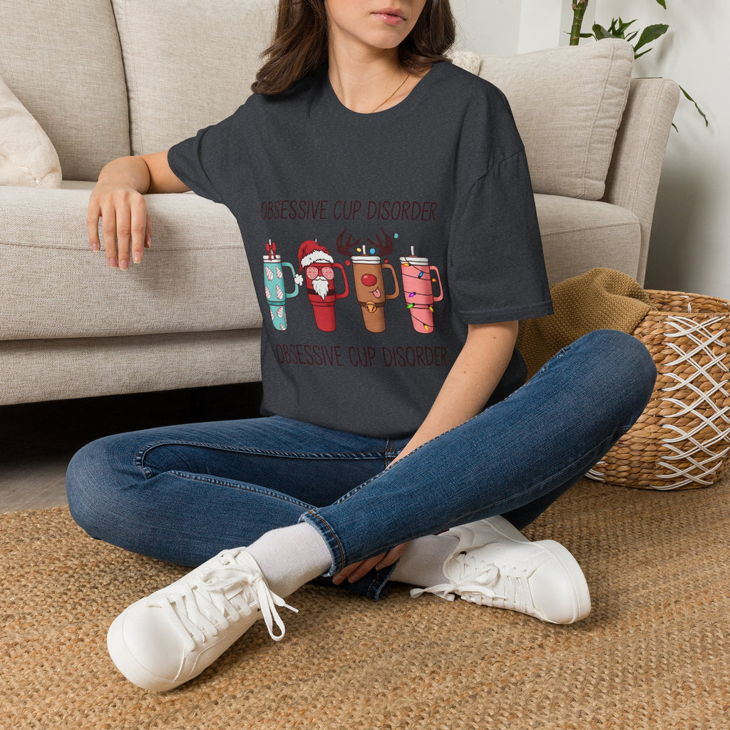 Obsessive Cup Disorder Funny Christmas Tumbler t-shirt in Dark Heather Grey, worn by a woman seated on a rug