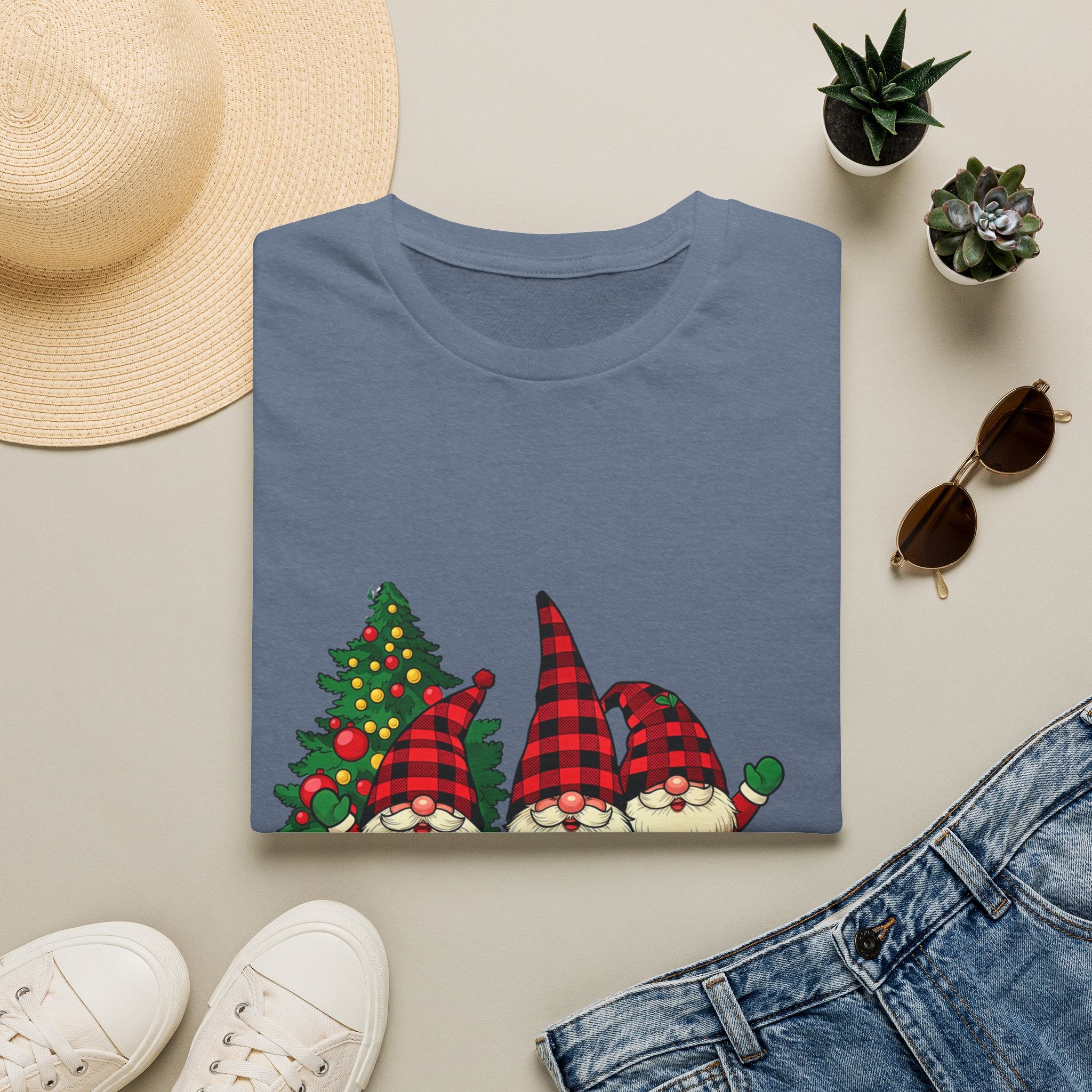 Buffalo Plaid Gnomes Red Truck print on a Heather Indigo t-shirt, folded beside a straw hat and jeans