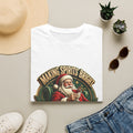 Making Spirits Bright and Stronger Santa print on a White t-shirt, folded beside a straw hat and jeans
