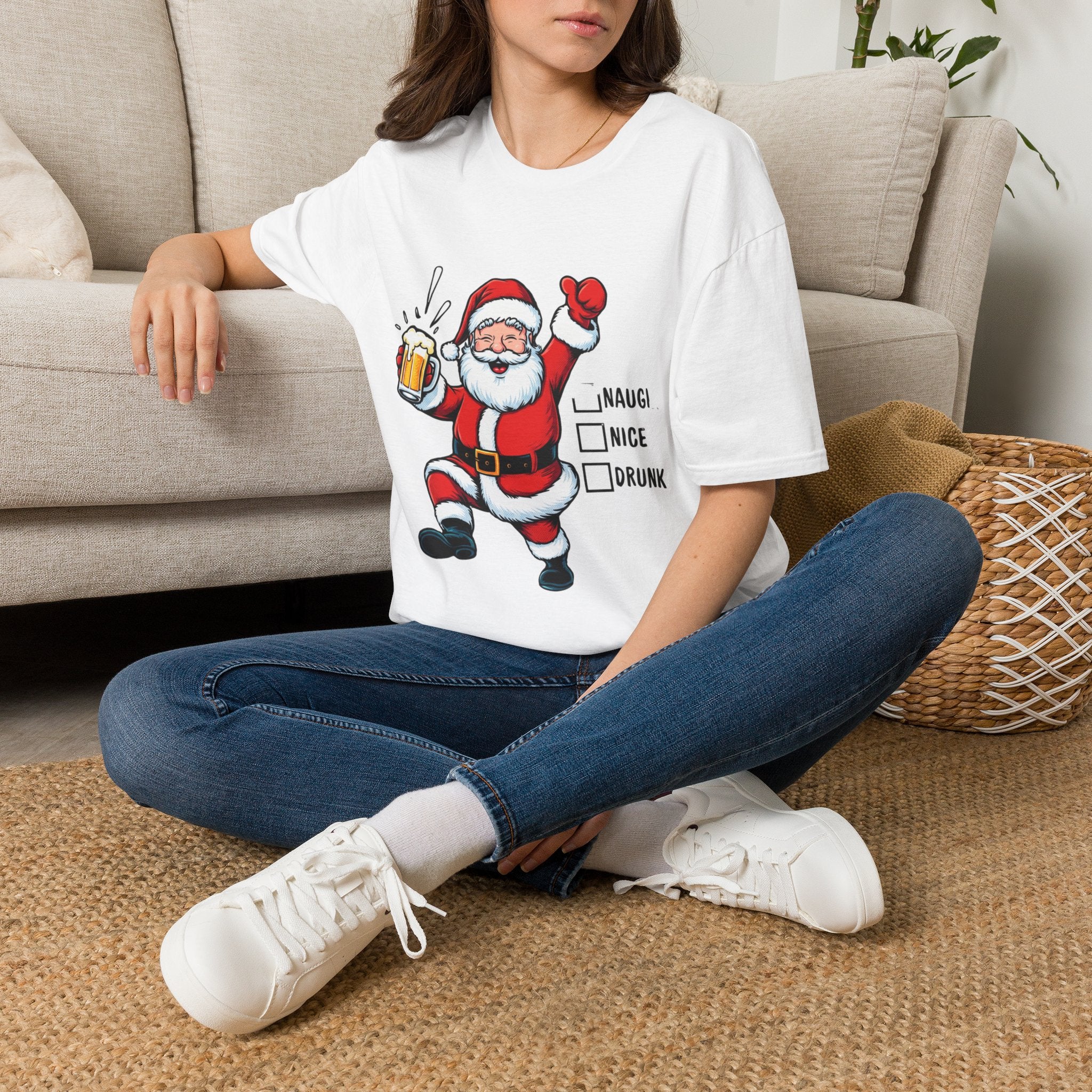 Naughty Nice Drunk Santa Beer Checklist t-shirt in White, worn by a woman seated on a rug