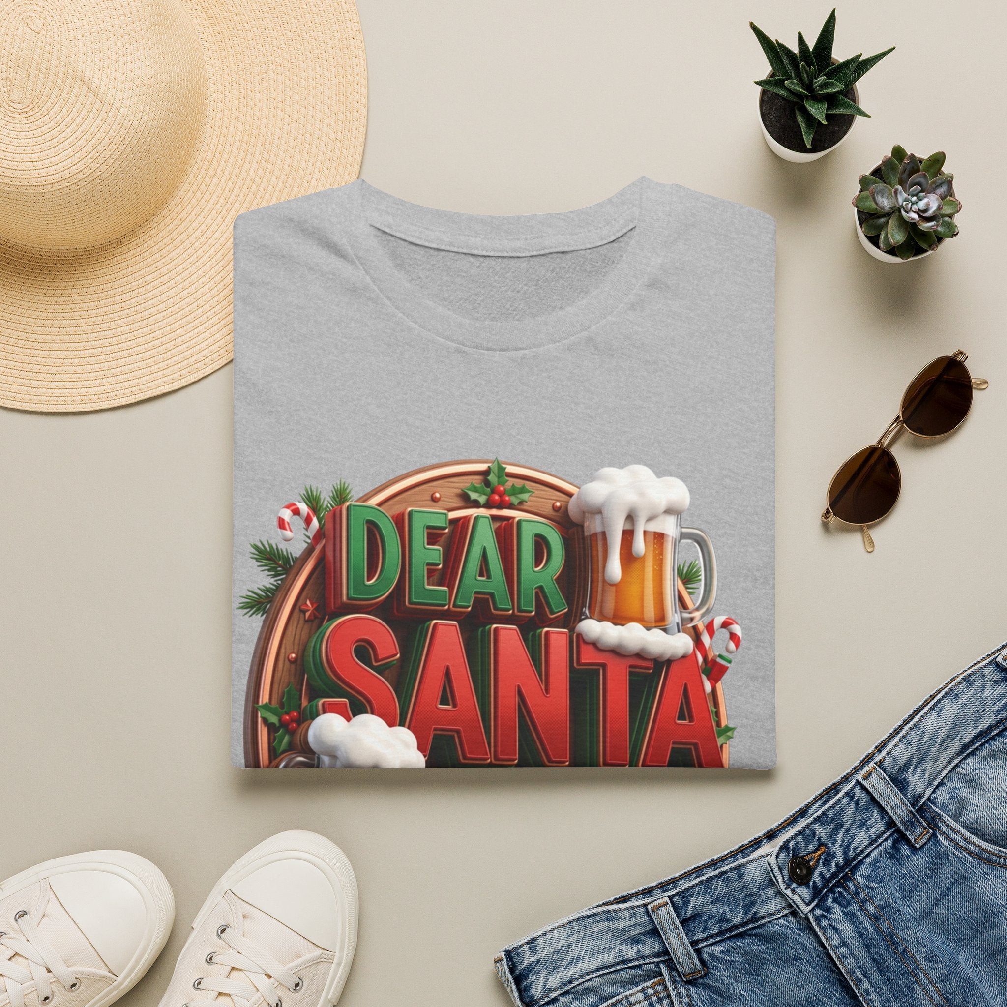Dear Santa Just Bring Beer Funny print on a Sport Grey t-shirt, folded beside a straw hat and jeans