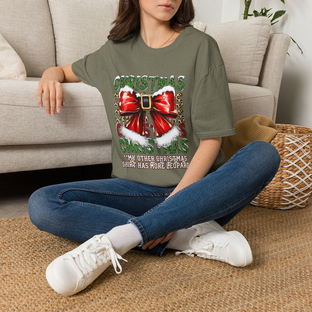 Stacked Christmas Leopard Print Santa Belt Bow t-shirt in Heather Military Green, worn by a woman seated on a rug