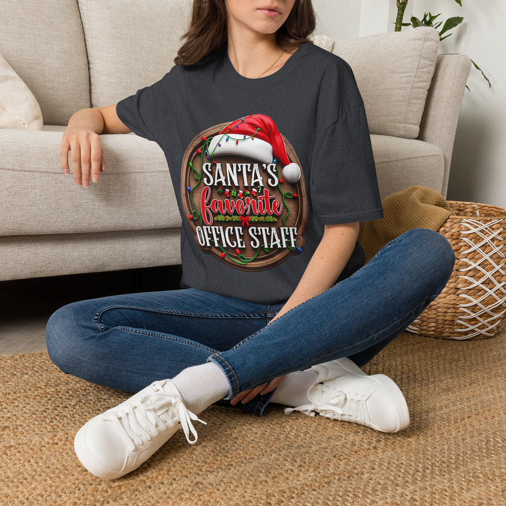 Santa's Favorite Office Staff t-shirt in Dark Heather Grey, worn by a woman seated on a rug