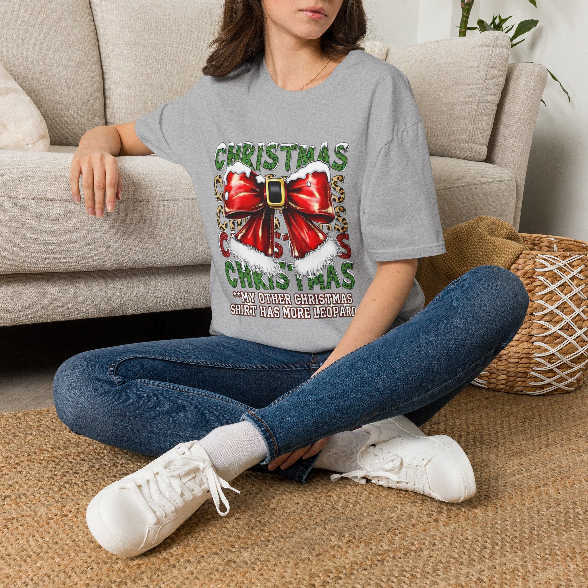 Stacked Christmas Leopard Print Santa Belt Bow t-shirt in Sport Grey, worn by a woman seated on a rug