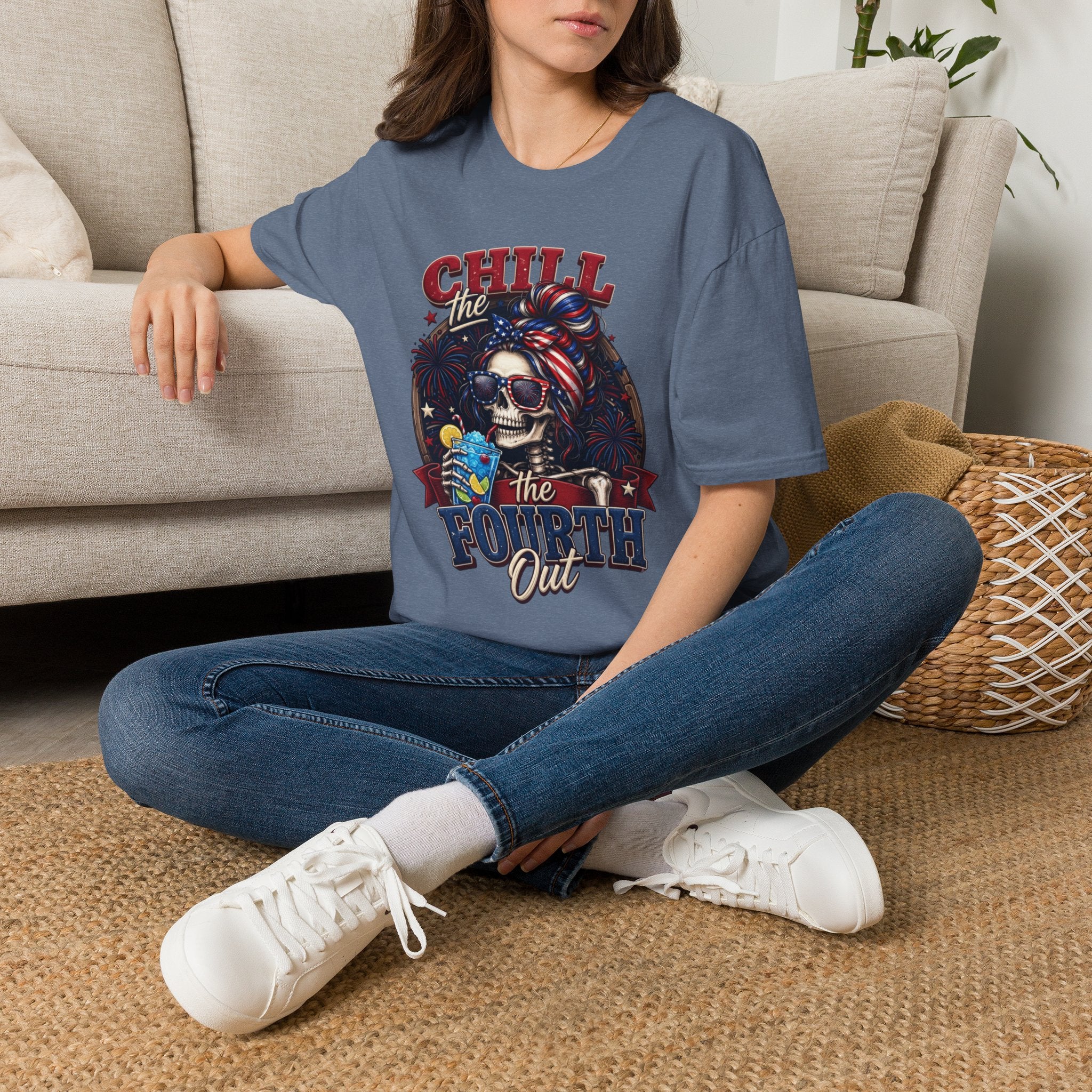 Chill the Fourth Out Patriotic Skeleton 4th of July t-shirt in Heather Indigo, worn by a woman seated on a rug