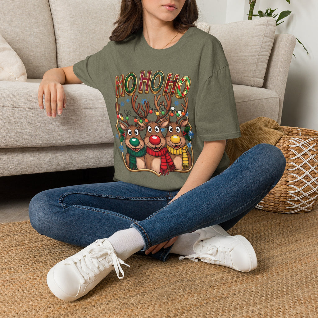 Reindeer Trio Ho Ho Ho Christmas Lights t-shirt in Heather Military Green, worn by a woman seated on a rug