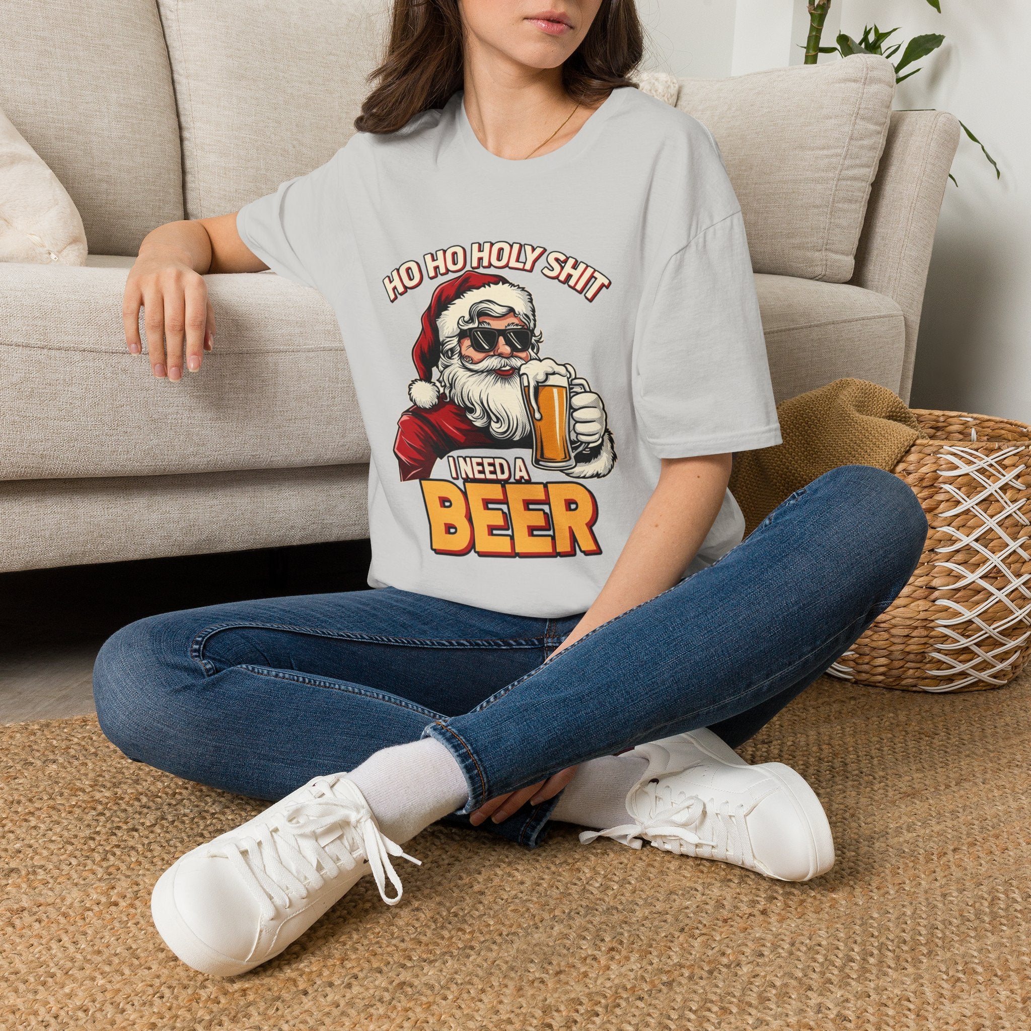 Ho Ho Holy Sh*t I Need a Beer t-shirt in Ice Grey, worn by a woman seated on a rug
