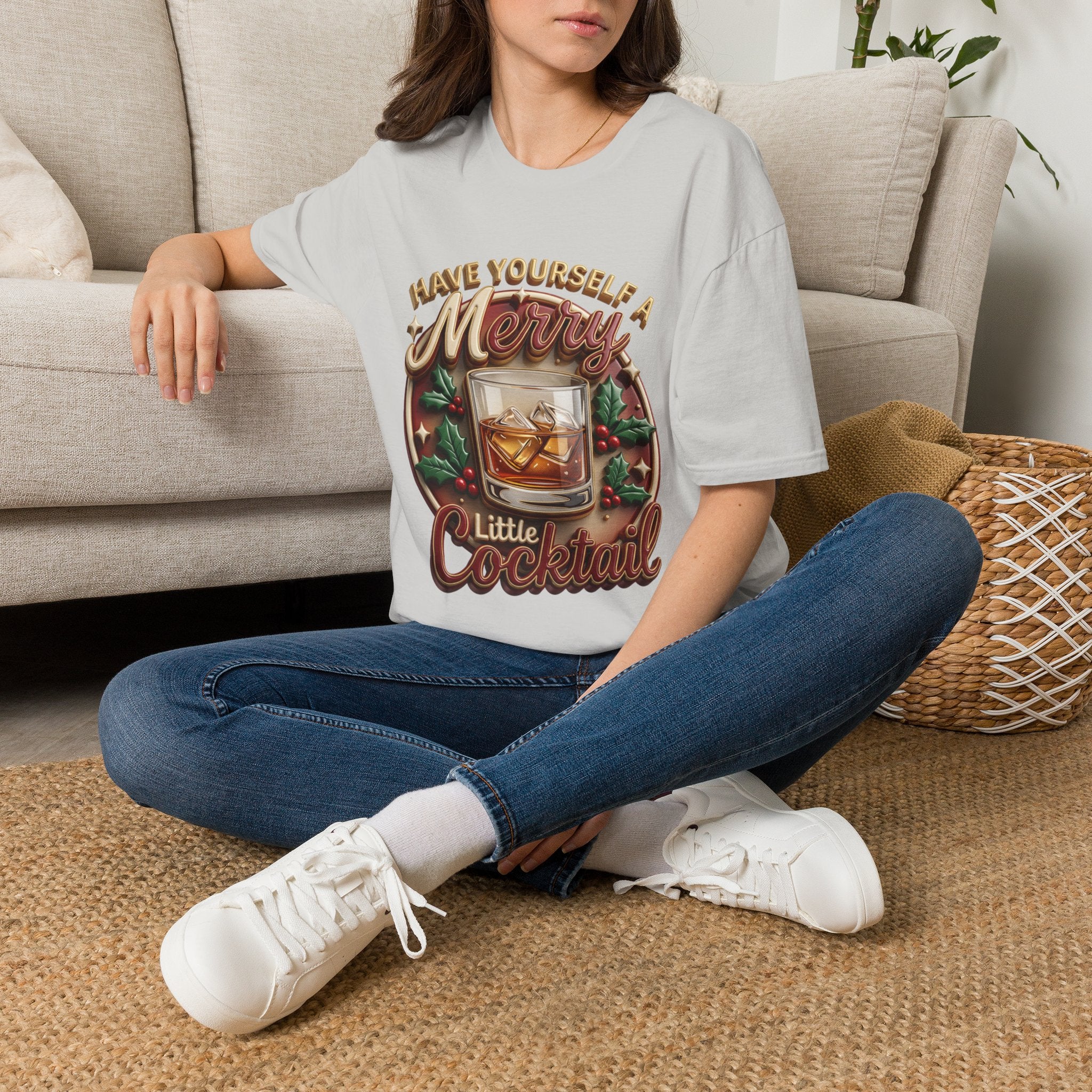 Have Yourself a Merry Little Cocktail t-shirt in Ice Grey, worn by a woman seated on a rug