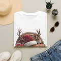 Merry Christmas Vintage Santa Hat & Antlers print on a White t-shirt, folded beside a straw hat and jeans