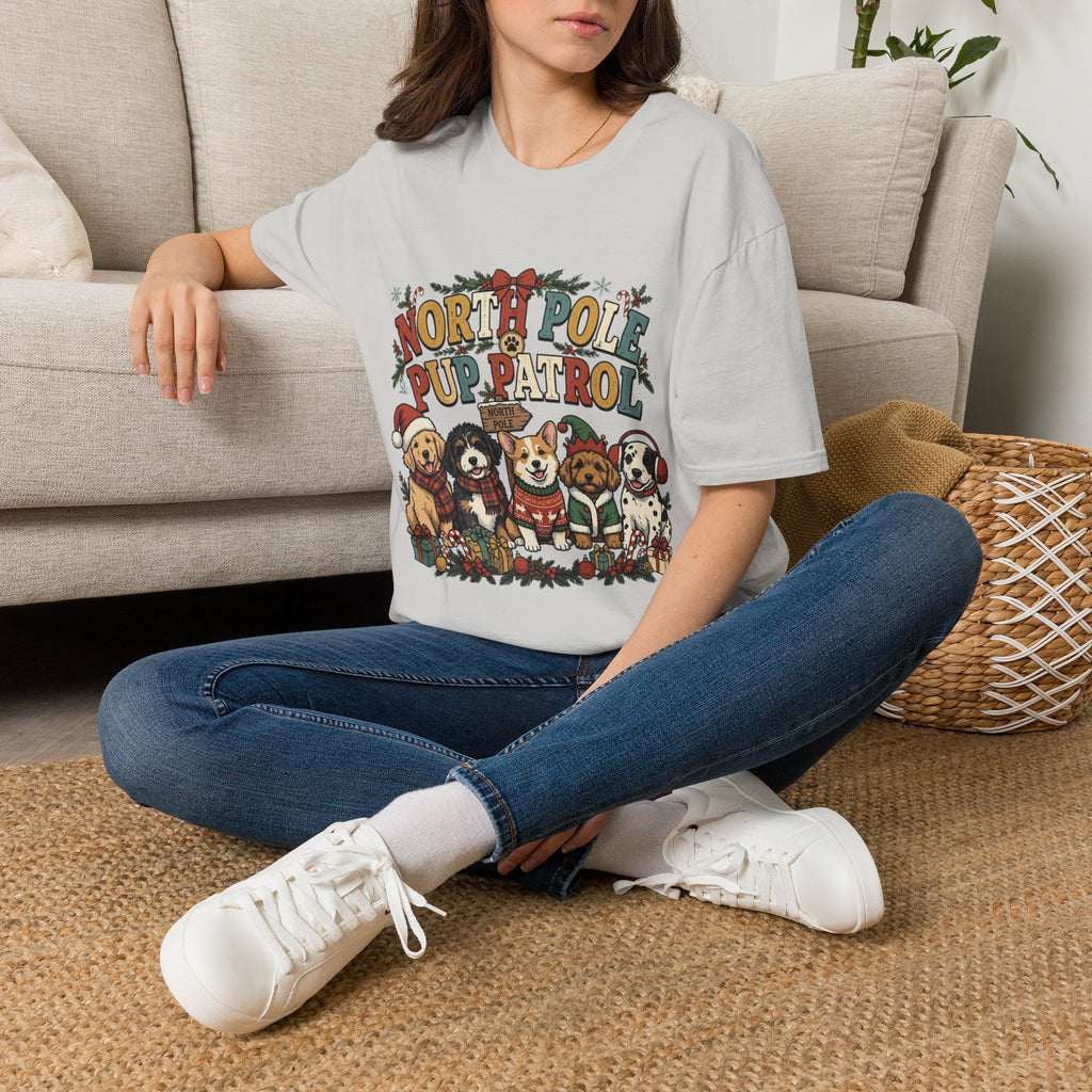 North Pole Pup Patrol Christmas Dogs t-shirt in Ice Grey, worn by a woman seated on a rug
