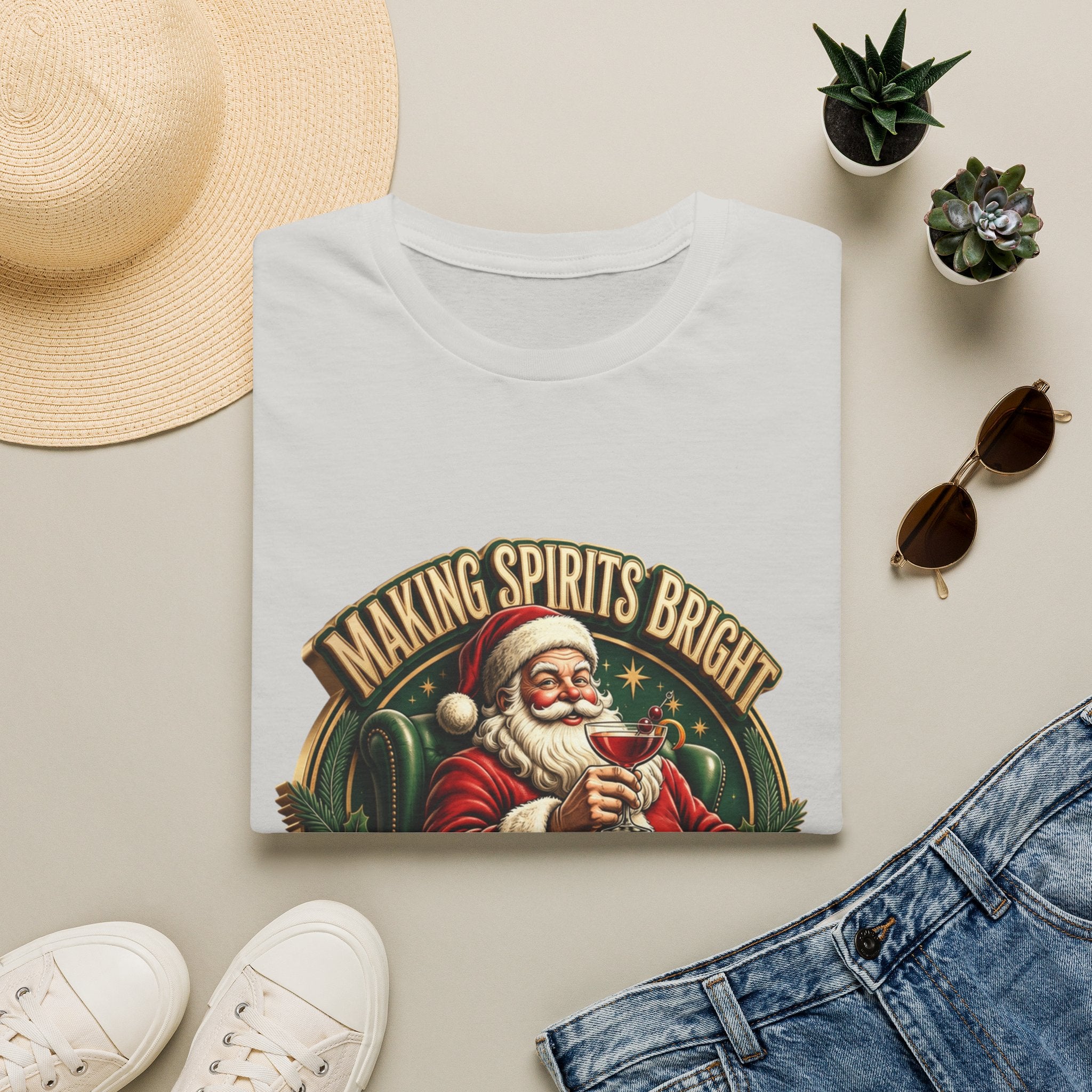 Making Spirits Bright and Stronger Santa print on an Ice Grey t-shirt, folded beside a straw hat and jeans