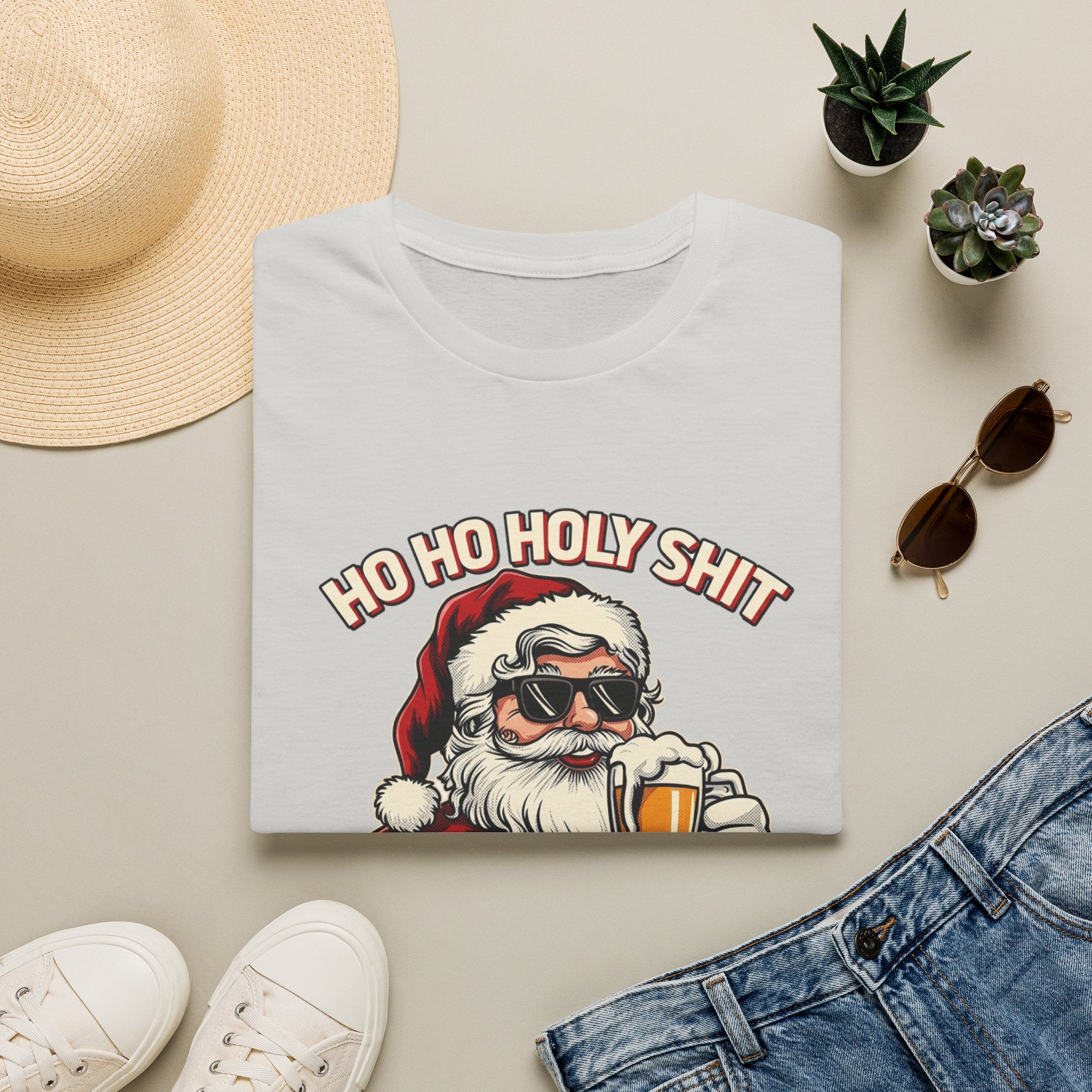 Ho Ho Holy Sh*t I Need a Beer print on an Ice Grey t-shirt, folded beside a straw hat and jeans