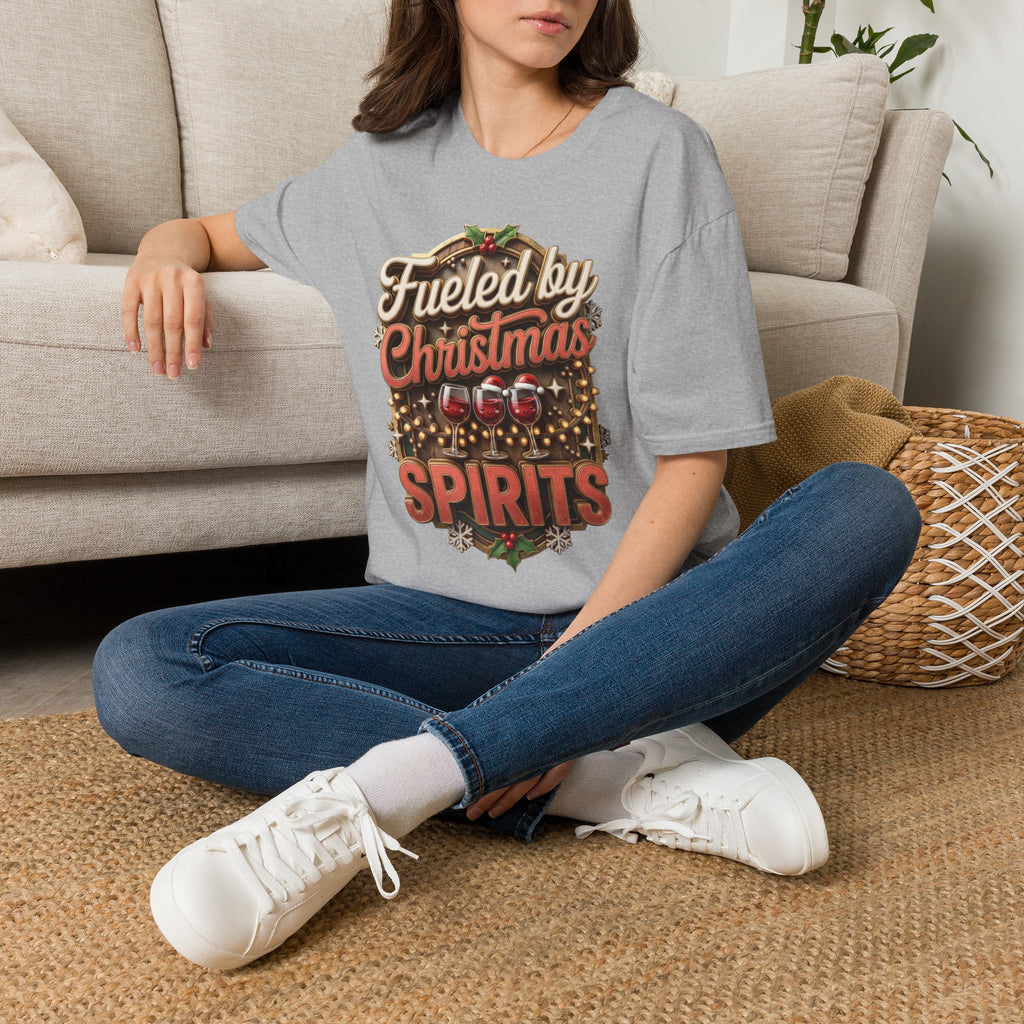 Fueled by Christmas Spirits Wine t-shirt in Sport Grey, worn by a woman seated on a rug