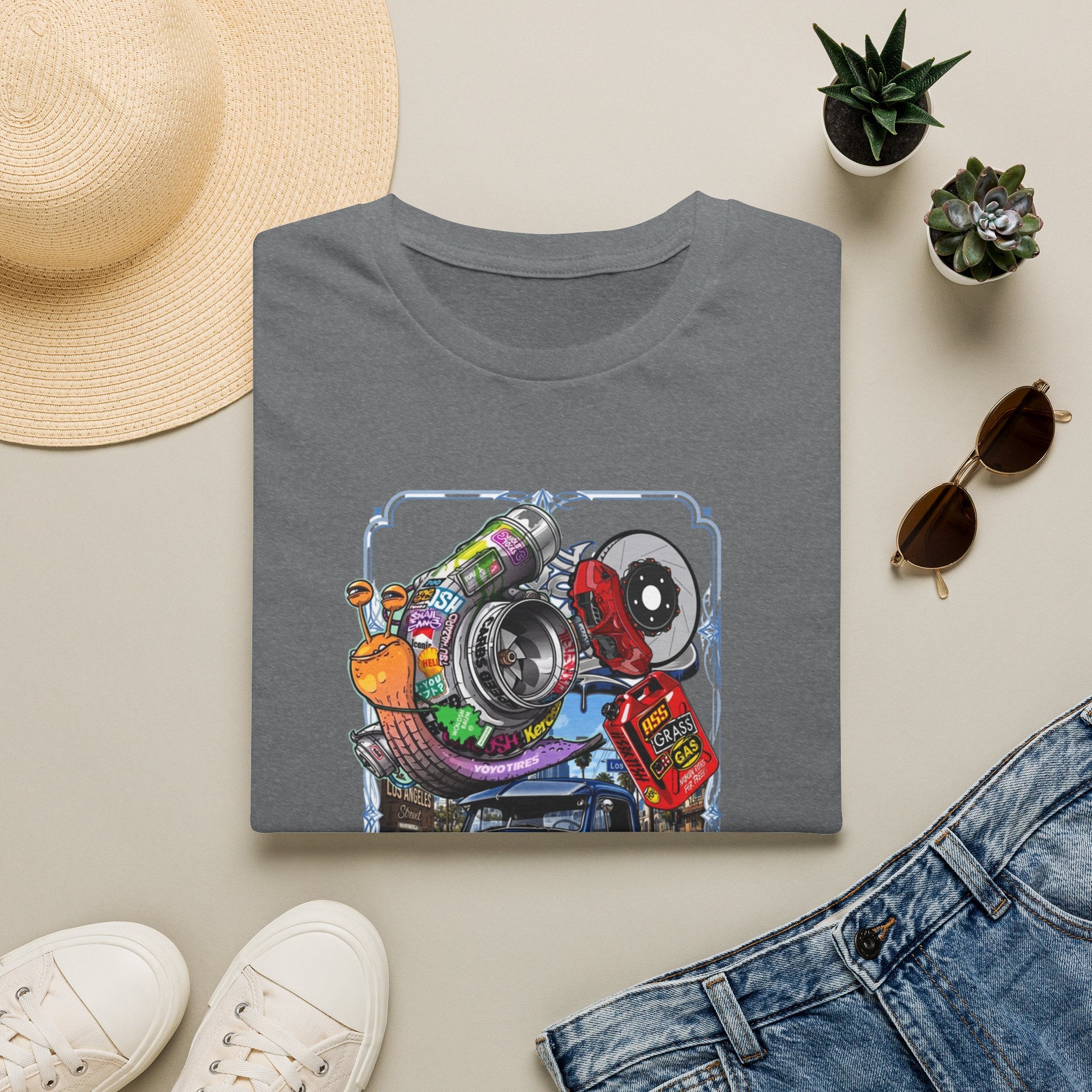 Turbocharged Snail Gearhead Car Parts print on a Graphite Heather t-shirt, folded beside a straw hat and jeans