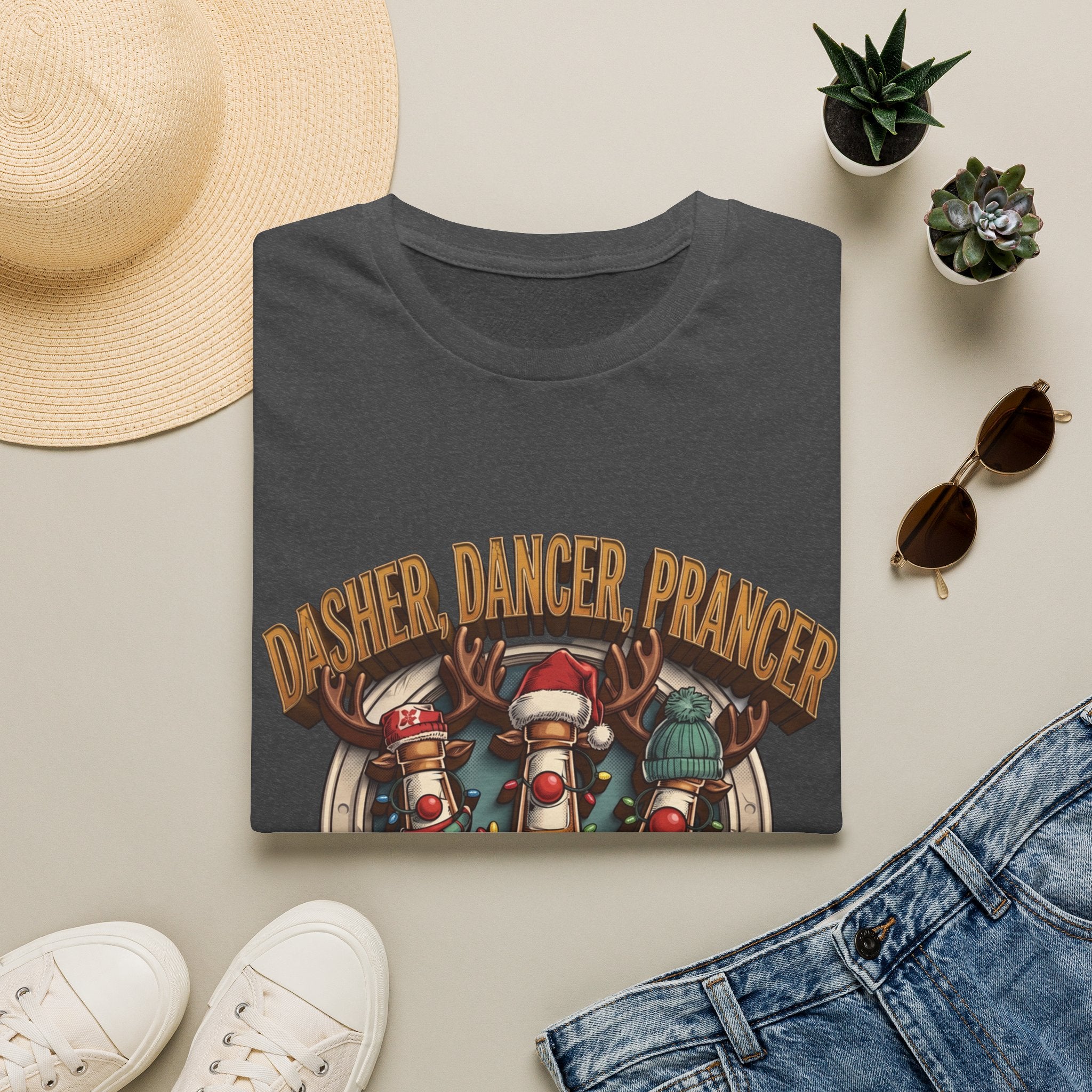 Dasher Dancer Prancer Reinbeer Christmas Beer print on a Dark Heather t-shirt, folded beside a straw hat and jeans