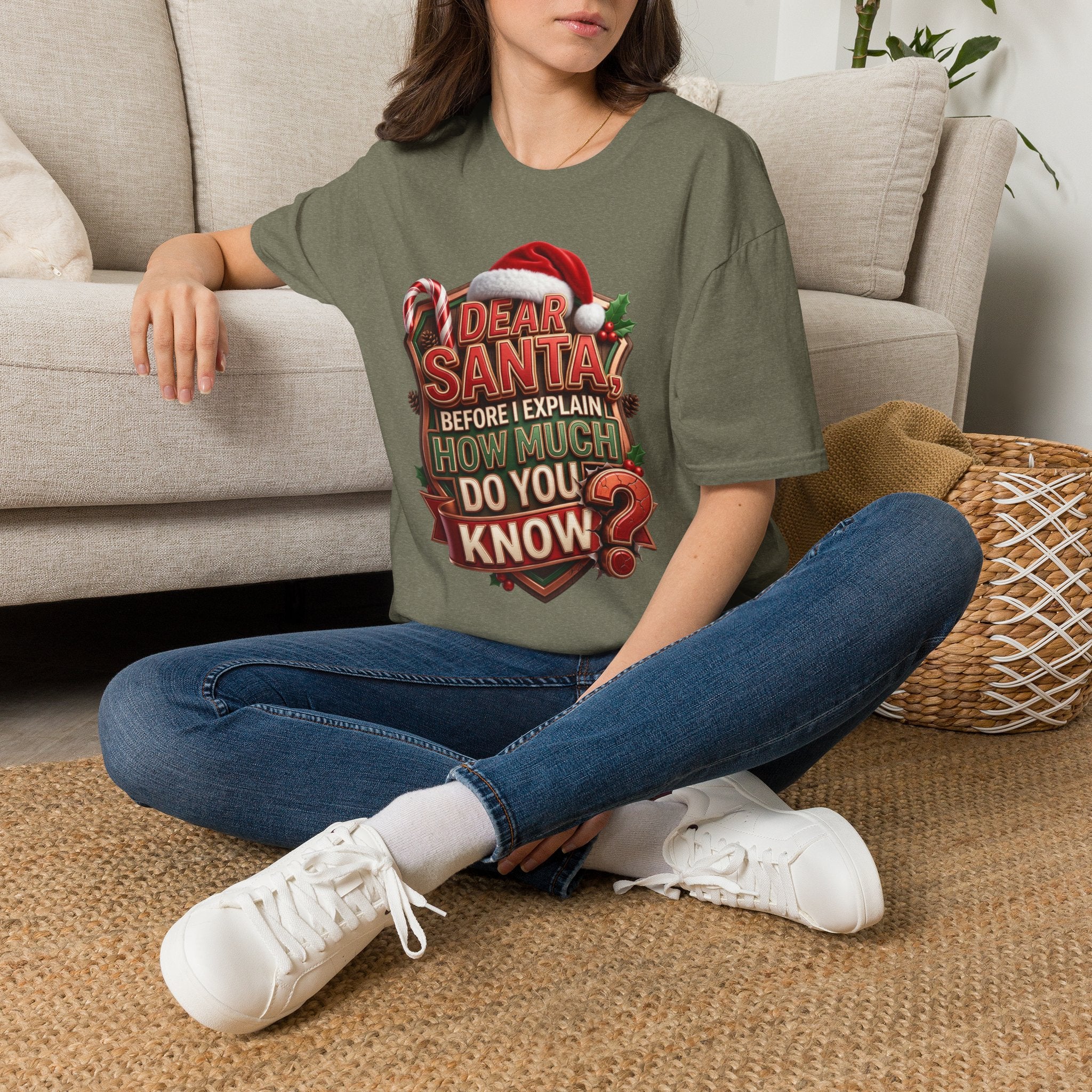Dear Santa Before I Explain t-shirt in Heather Military Green, worn by a woman seated on a rug