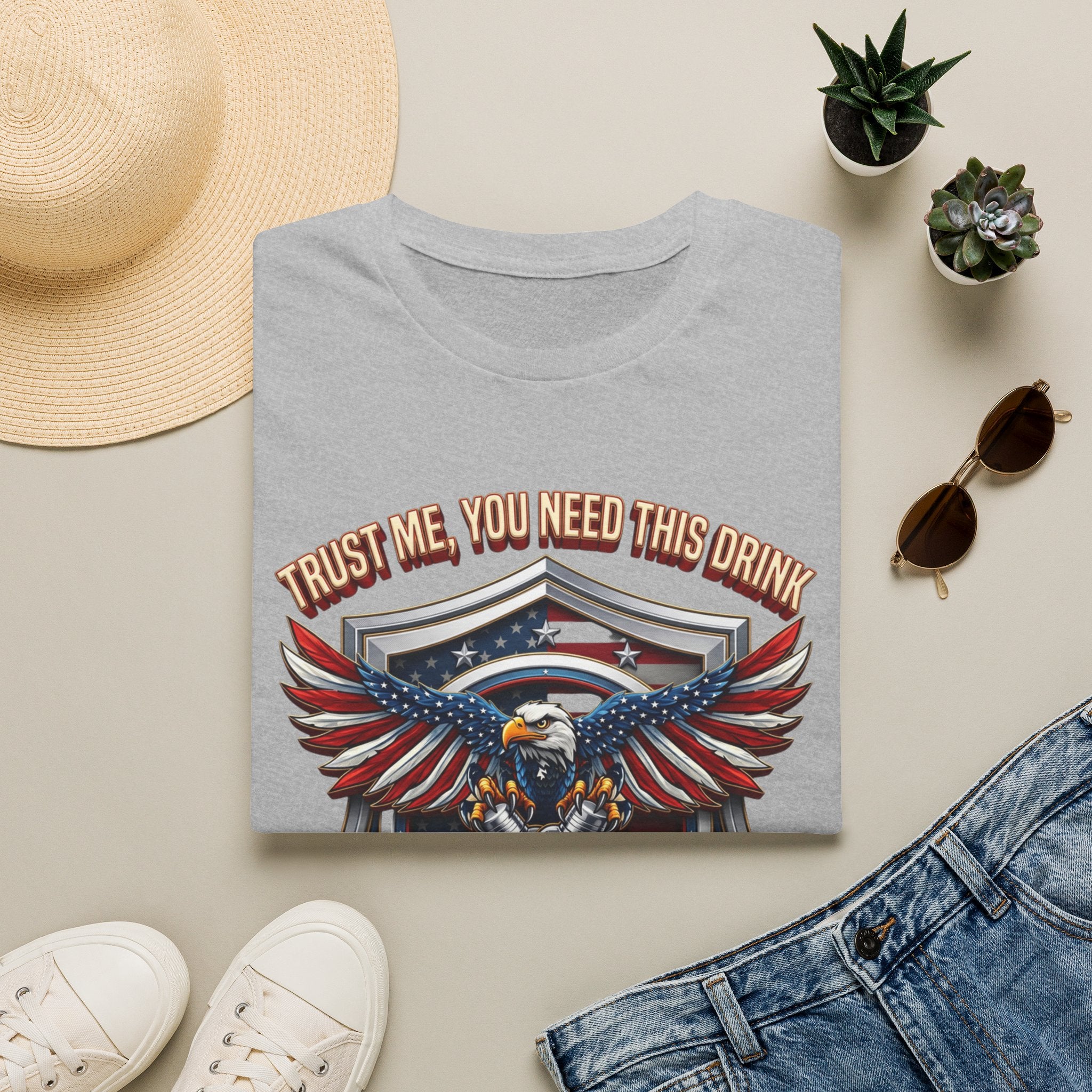Bartender Eagle Trust Me You Need This Drink print on a Sport Grey t-shirt, folded beside a straw hat and jeans