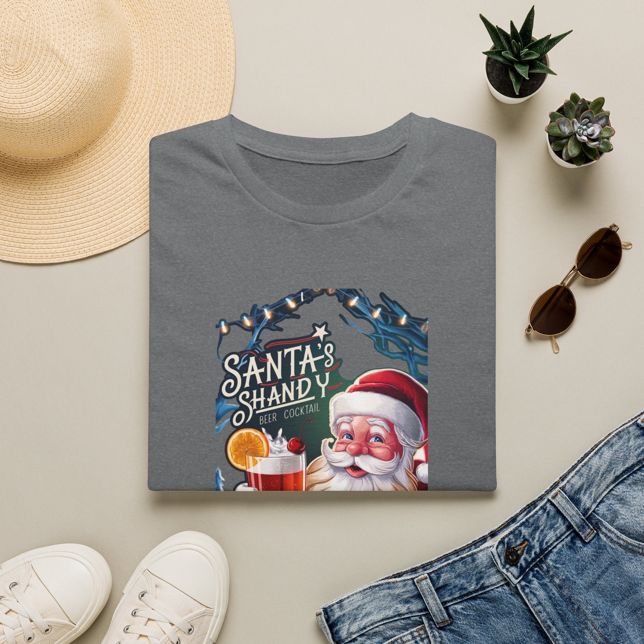 Santa's Shandy Beer Cocktail print on a Graphite Heather t-shirt, folded beside a straw hat and jeans