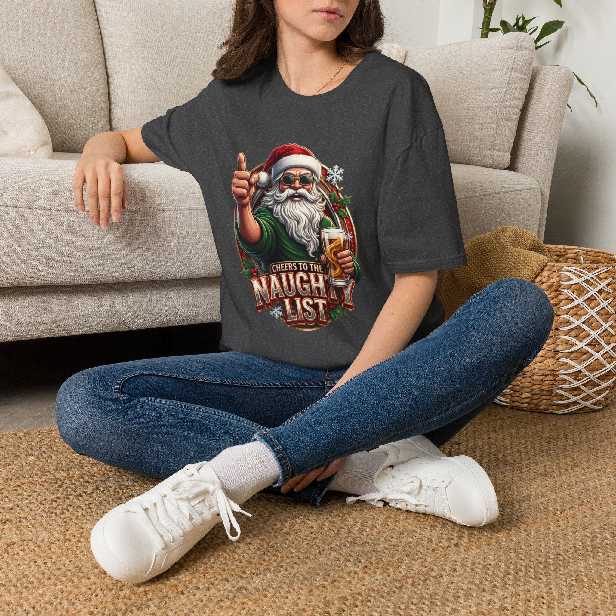 Cheers to the Naughty List Santa Beer t-shirt in Dark Heather, worn by a woman seated on a rug