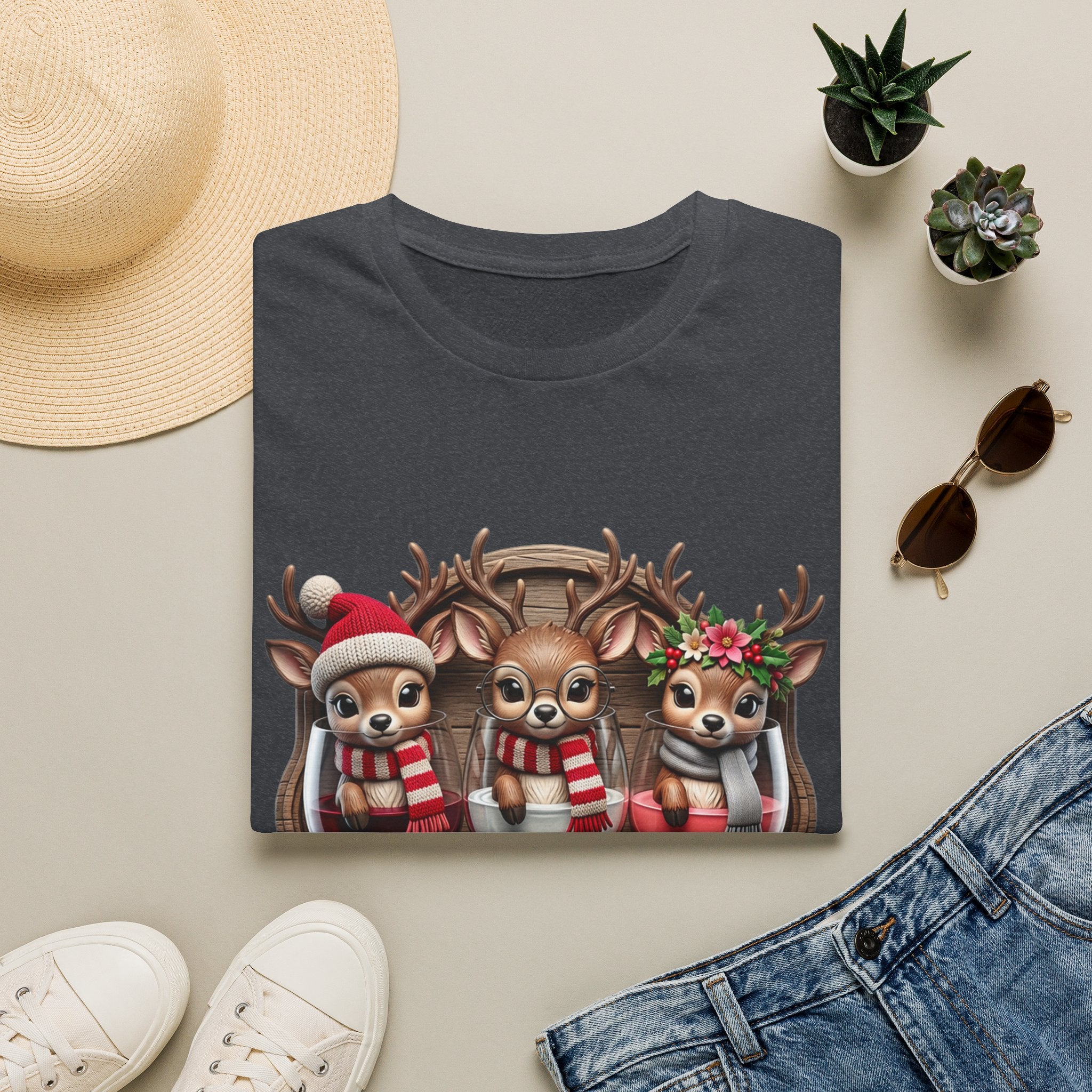 Drink Drank Drunk Reindeer Wine Trio print on a Dark Heather Grey t-shirt, folded beside a straw hat and jeans